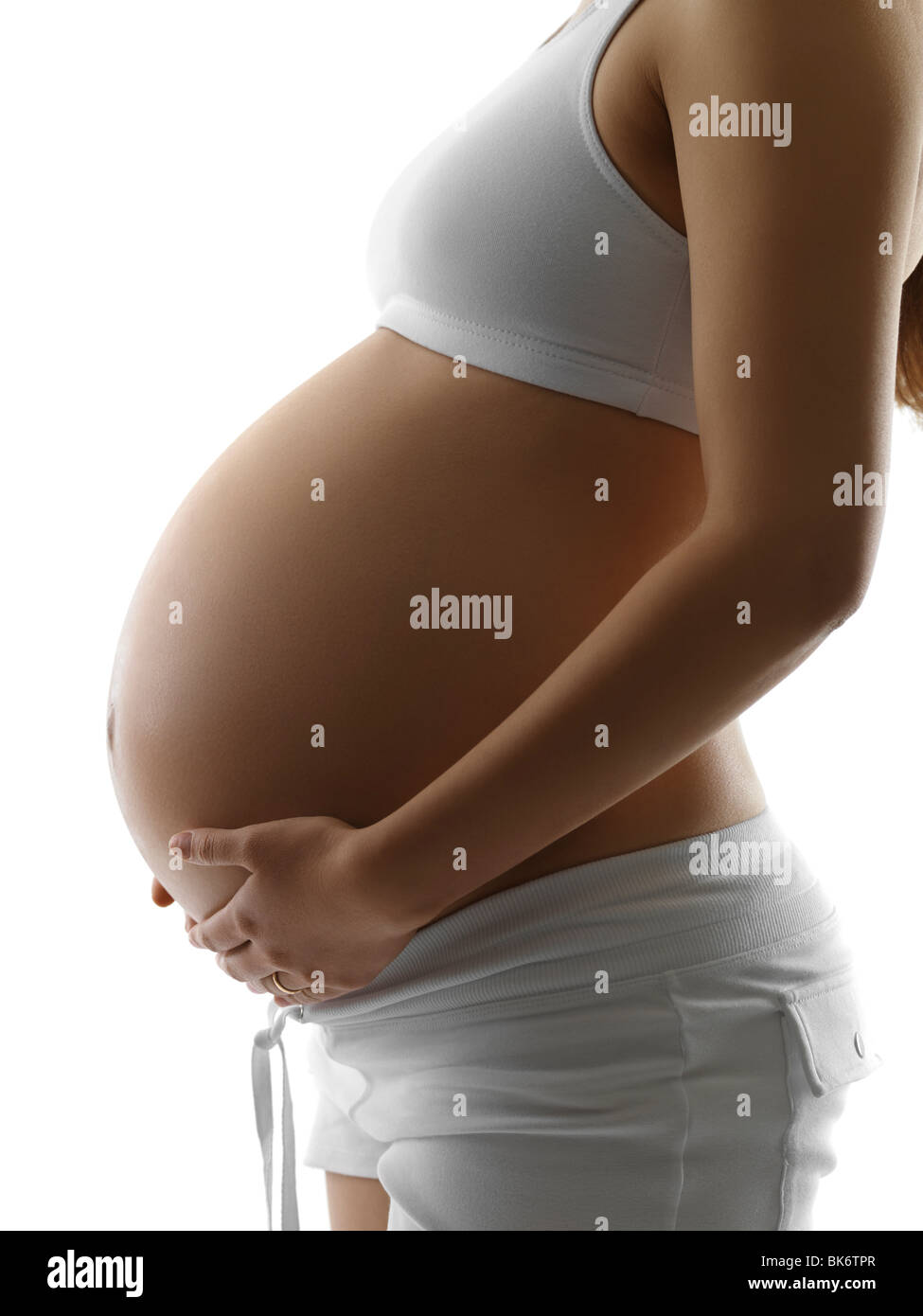 Pregnant young woman in a sporty outfit isolated on white background Stock Photo