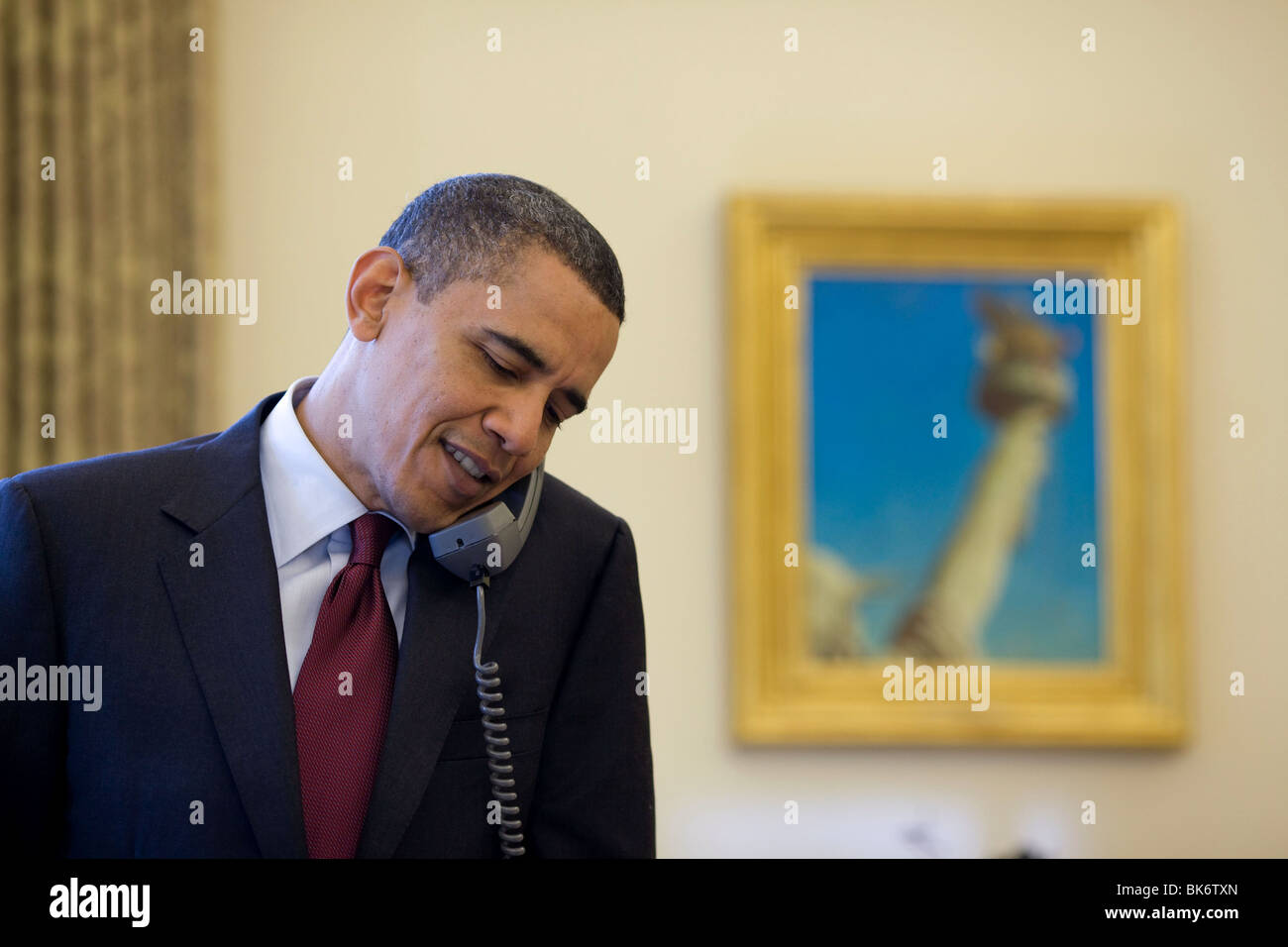 President Barack Obama talks on the phone with Associate Justice John Paul Stevens, in the Oval Office. Stock Photo