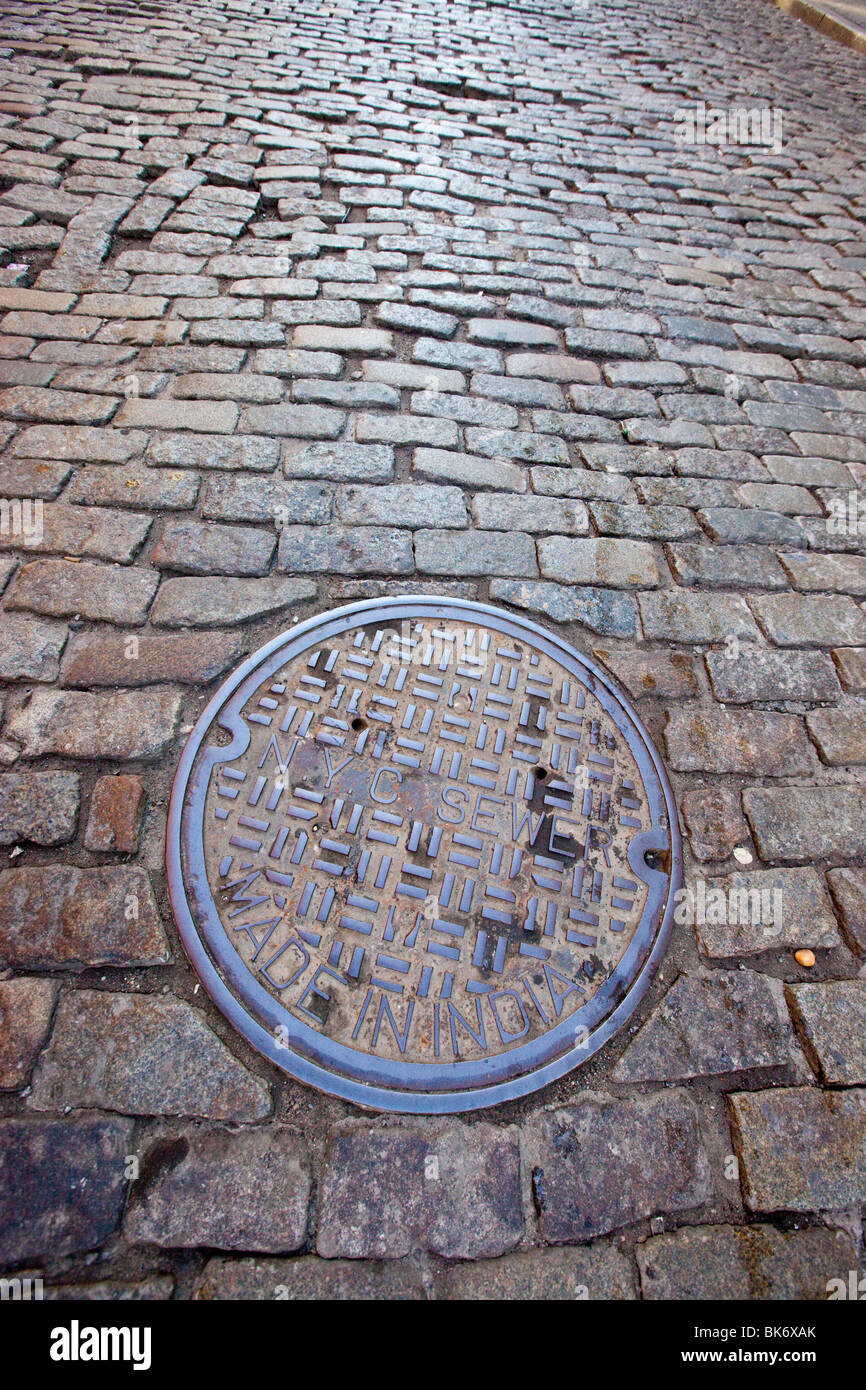 New York sewer cover on a cobblestone street in Tribeca, Manhattan, New York Stock Photo