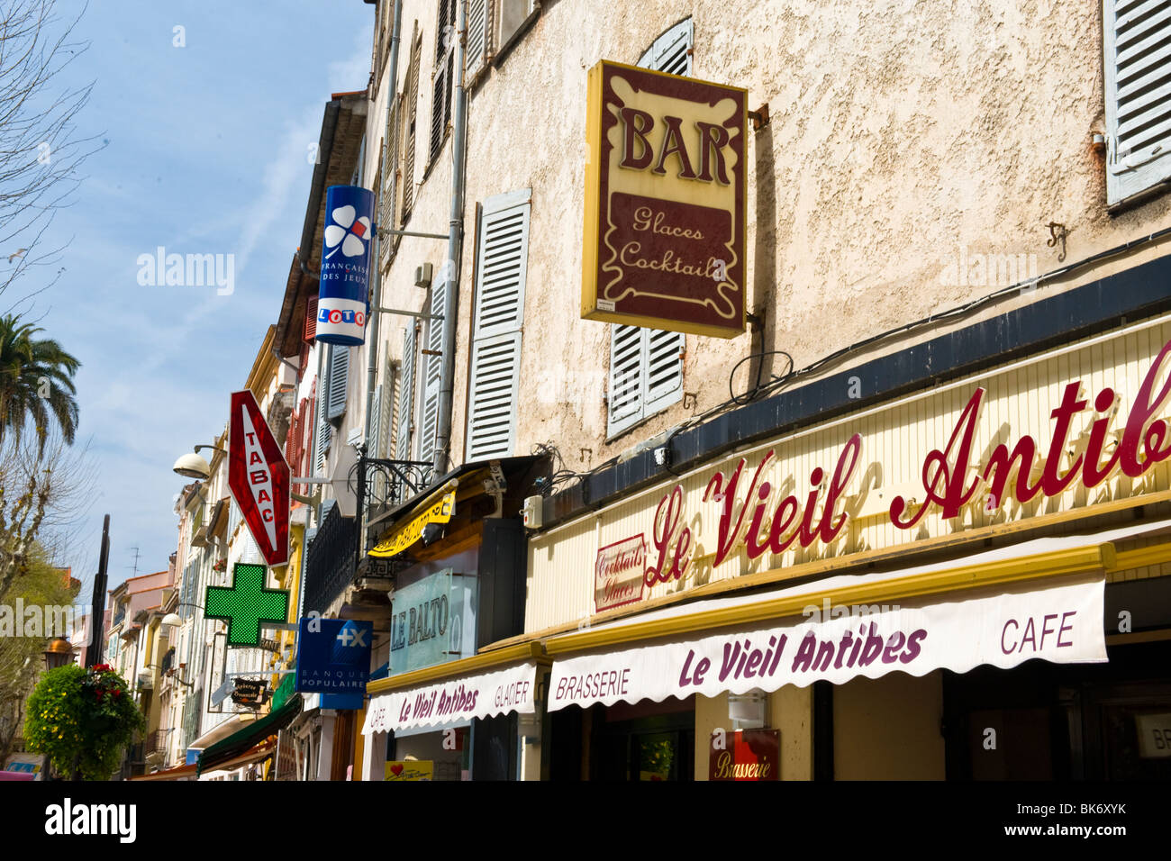 Antibes , typical shop or store arcade with Tabac , loto & pharmacy signs & Le Vieil Antibes brasserie , cafe or restaurant Stock Photo