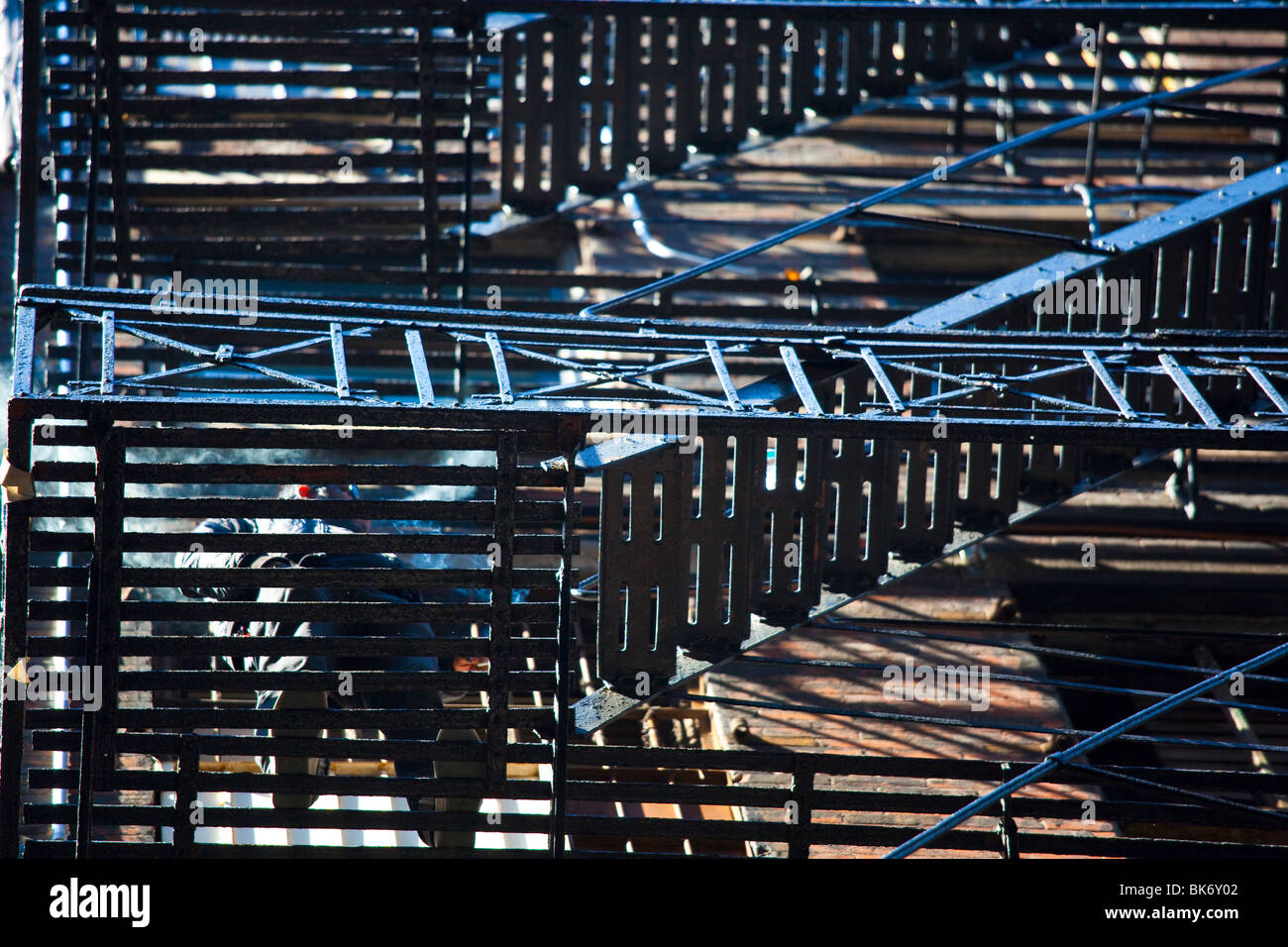 Man smoking on a fire escape in Cortlandt Alley, Tribeca, New York City Stock Photo