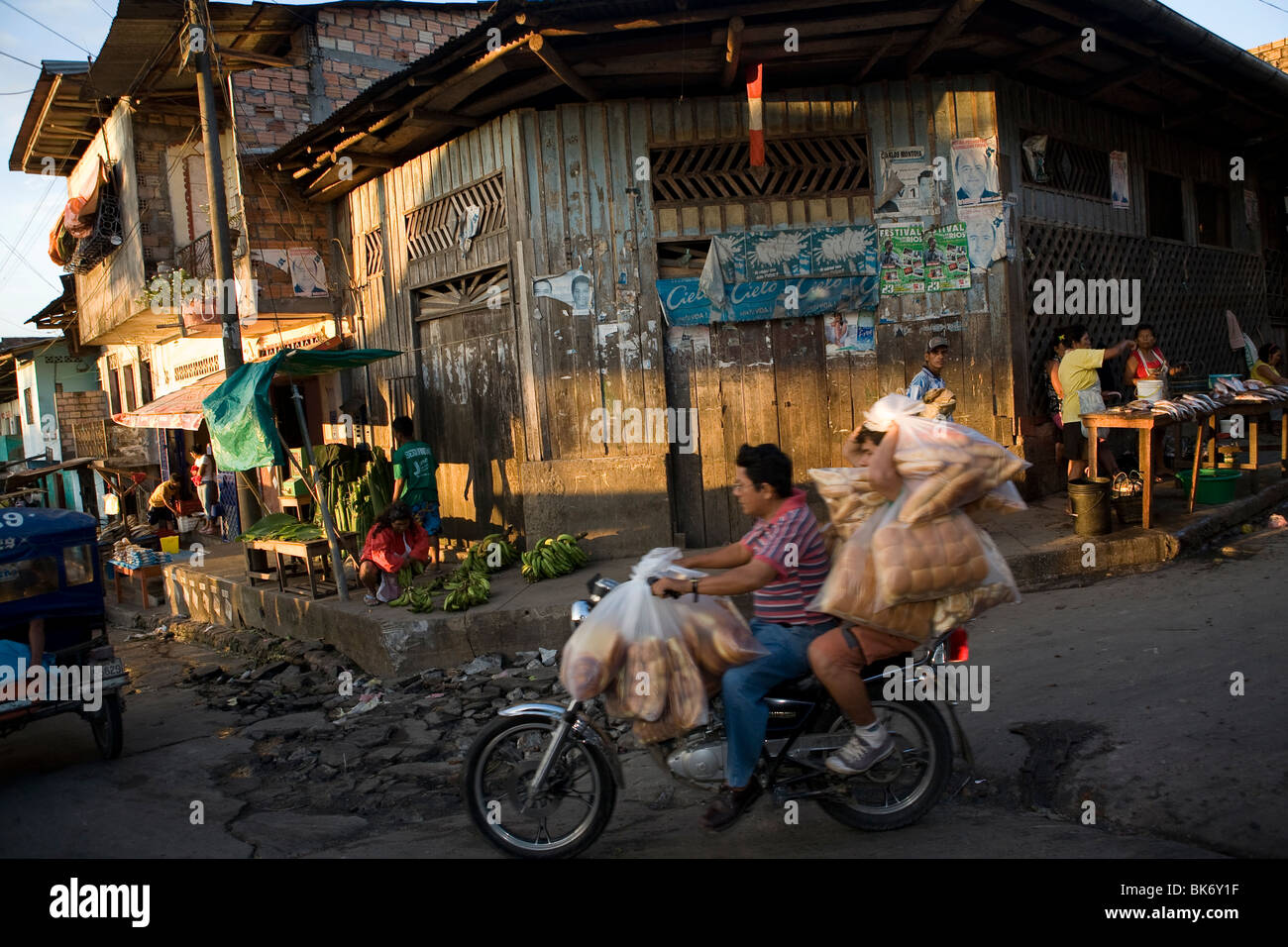 A motorcyclist drives down a street in Puerto Belen, Iquitos, in Peru's Amazon Basin. Stock Photo