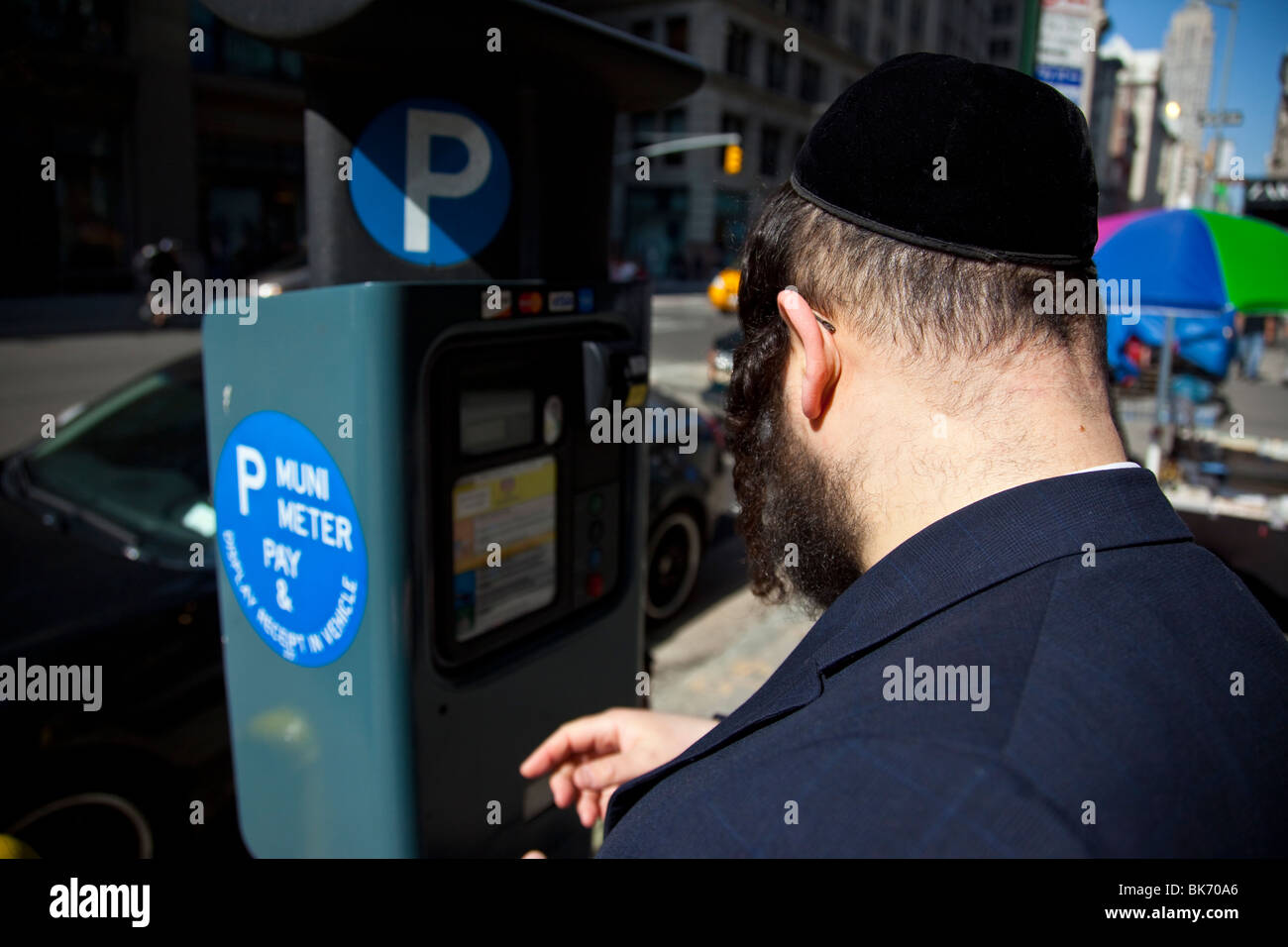 Jewish man using a parking meter in Manhattan, New York City Stock Photo