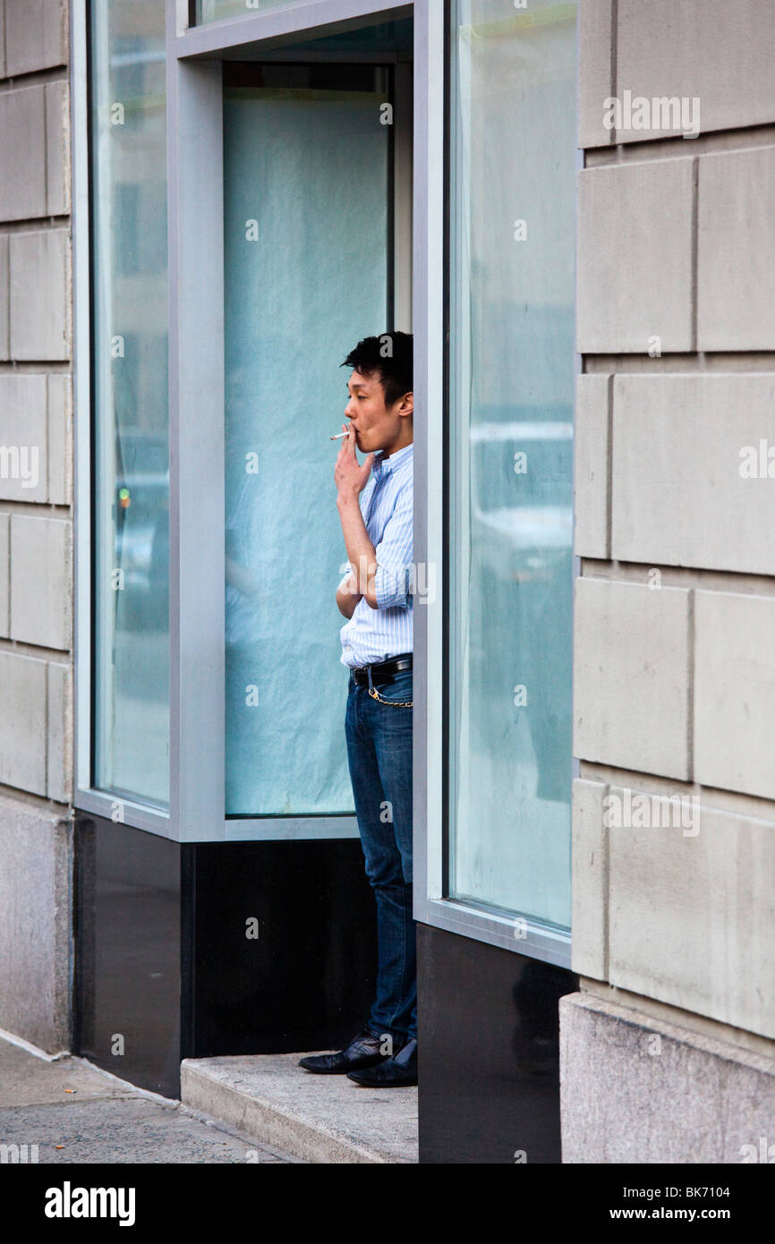 Asian man taking a cigarette break in Chelsea, New York Stock Photo