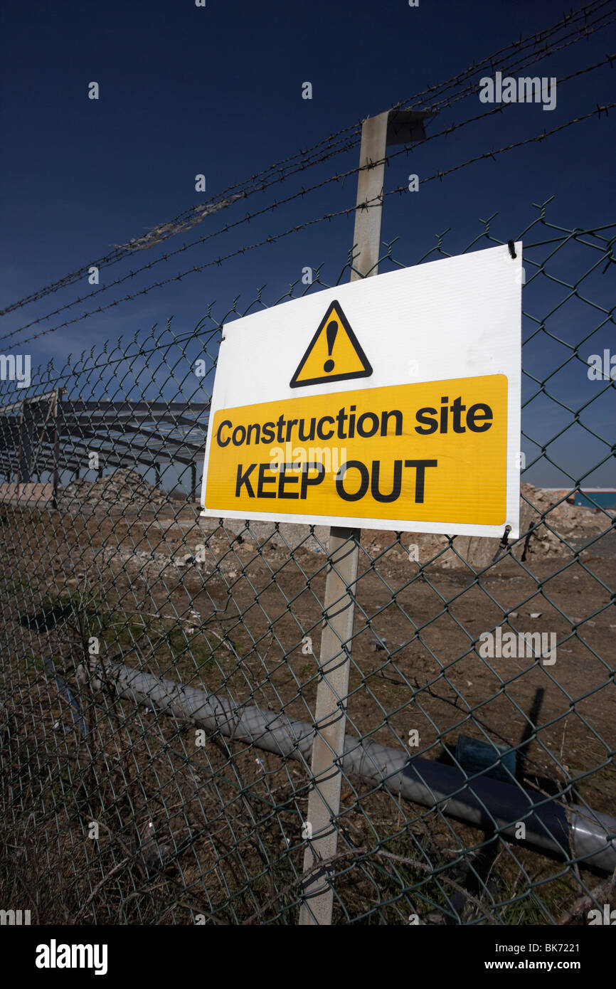 construction site keep out sign on a chain link fence surrounding a redevelopment building site Stock Photo