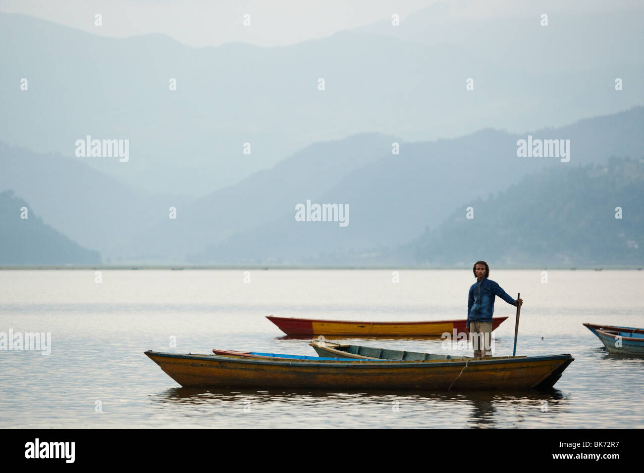 A man stands in a canoe on Pewha Lake in Pokhara, Nepal on Monday October 26, 2009. Stock Photo
