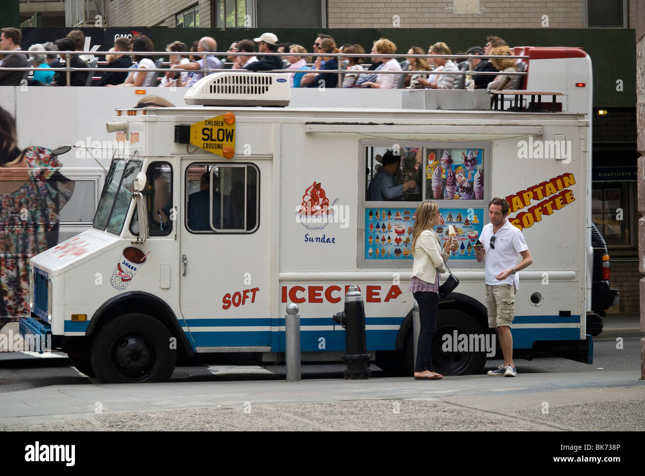 Ice cream lovers enjoy a frosty treat from a Captain Softee soft ice cream truck in Greenwich Village in New York Stock Photo