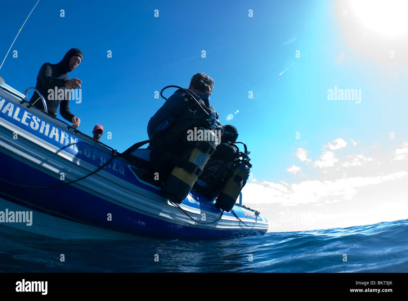 Scuba divers preparing for back-roll entry from a diving boat. Stock Photo