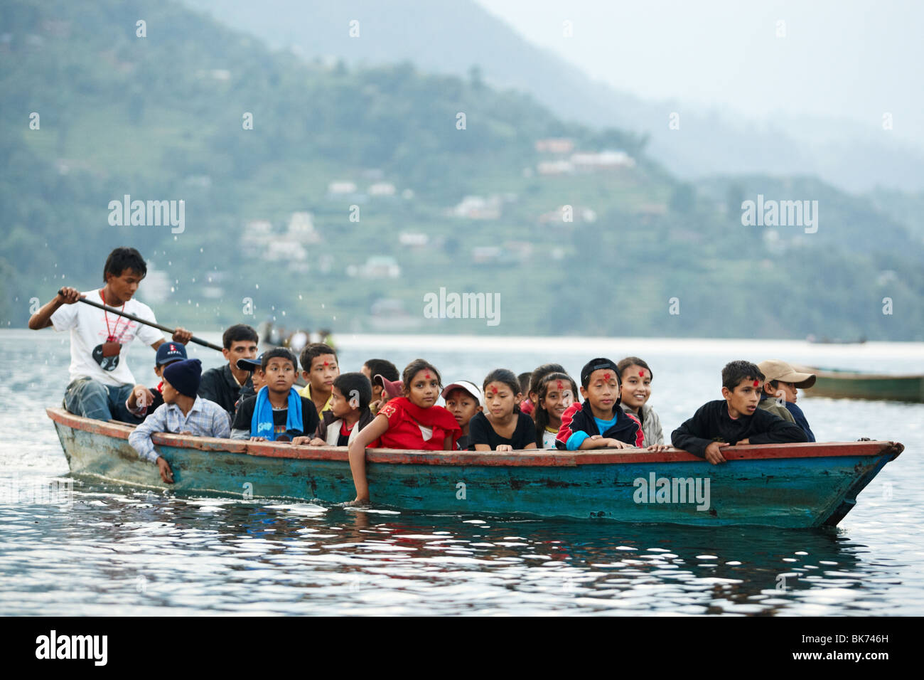 School children ride a canoe across Pewha Lake in Pokhara, Nepal on Monday October 26, 2009. Stock Photo