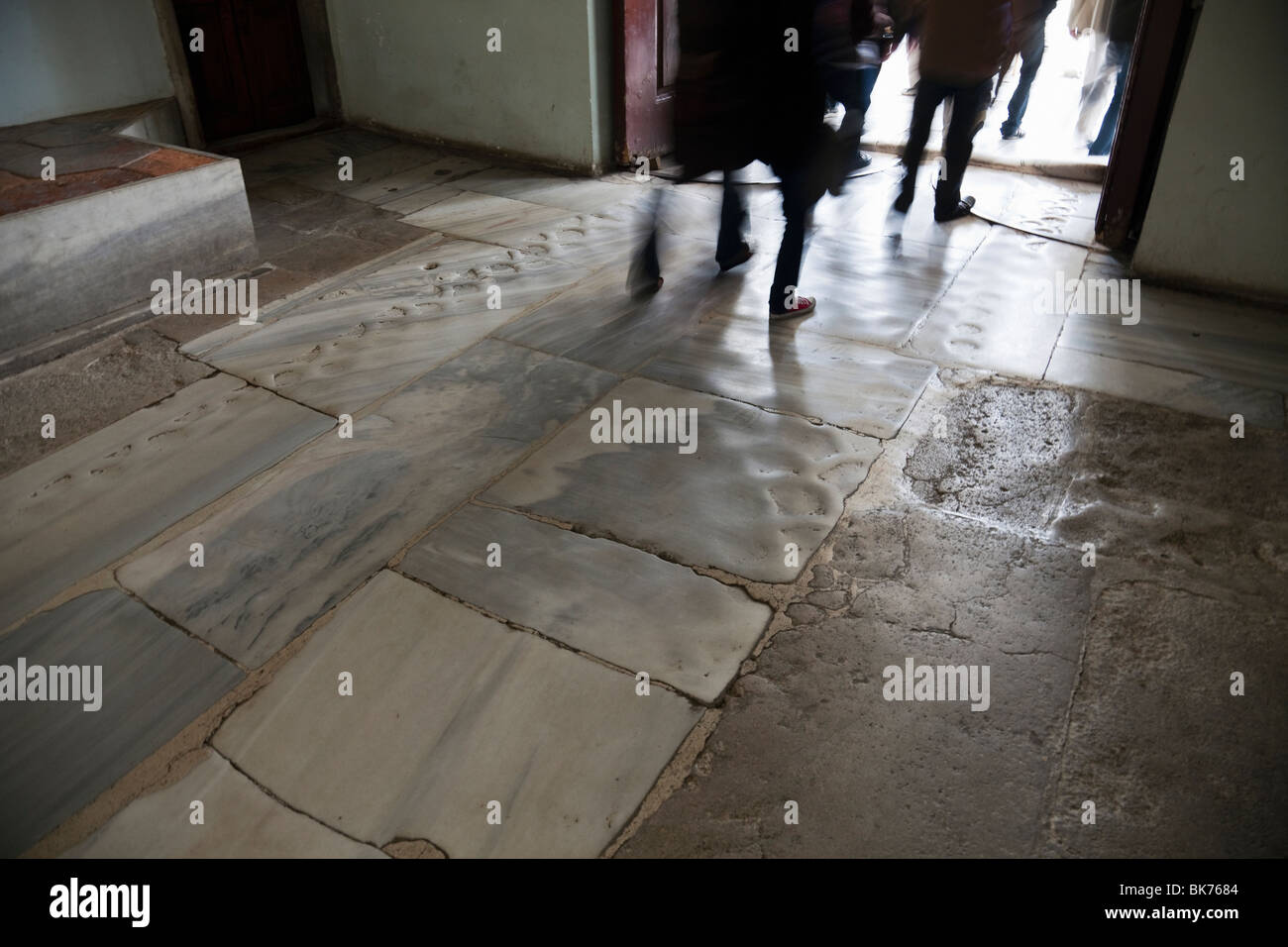 Blurred legs of tourists entering Topkapi Museum in Istanbul over marble entry worn down from millions of feet. Stock Photo