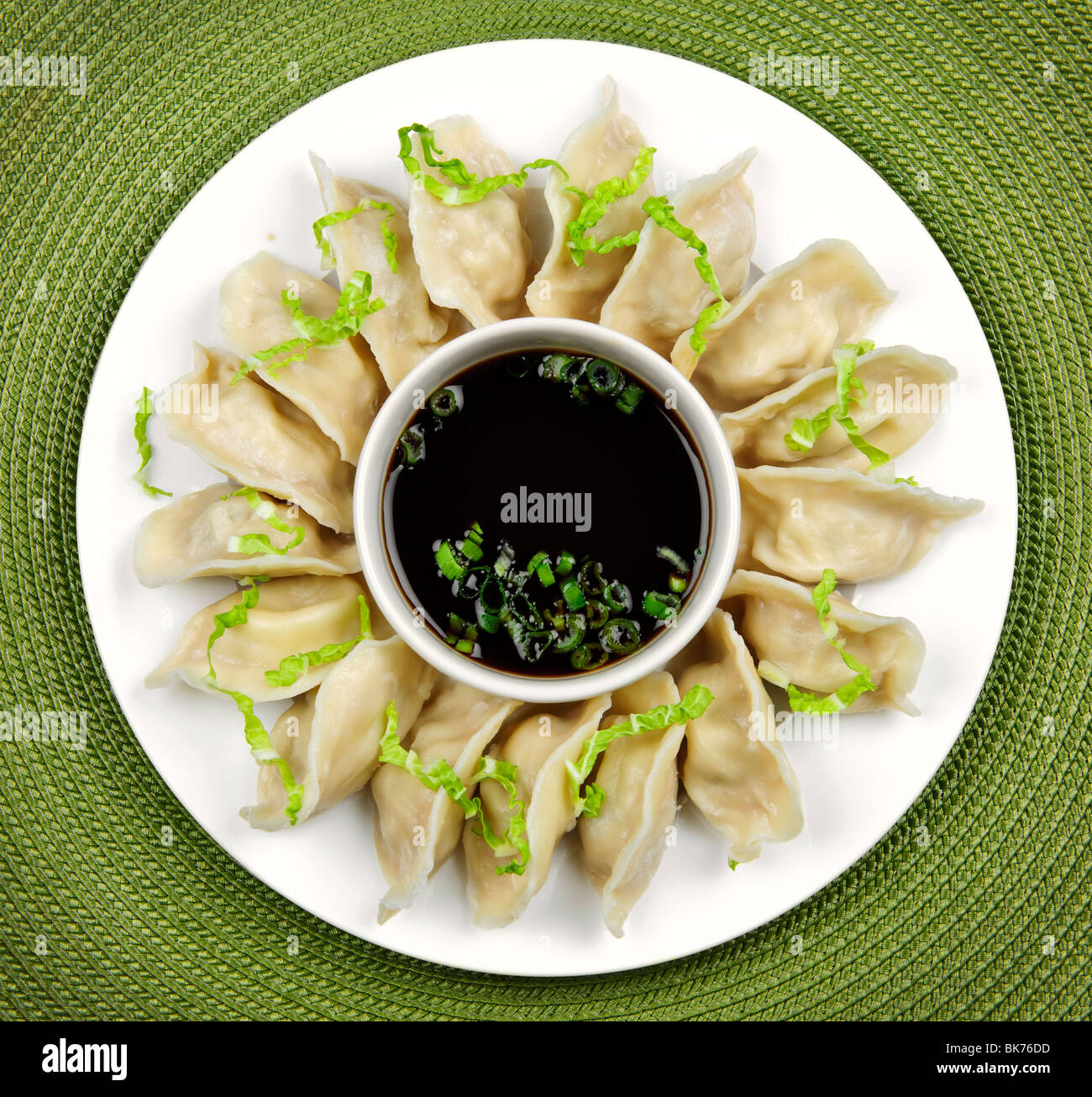 Plate of steamed dumplings with soy sauce from above Stock Photo