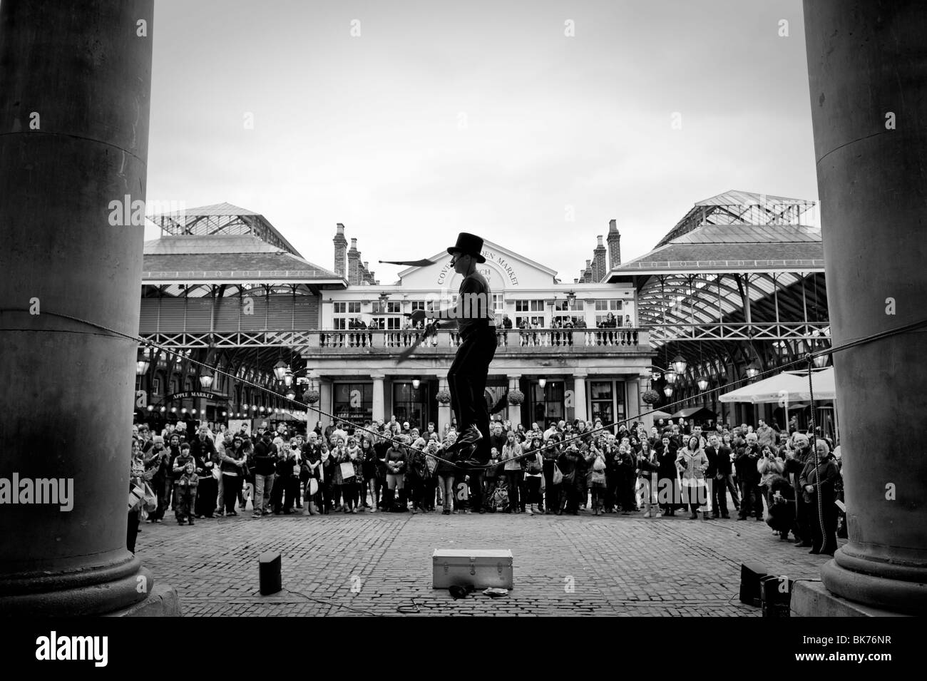 A knife juggler performs in the market of Covent Garden of London