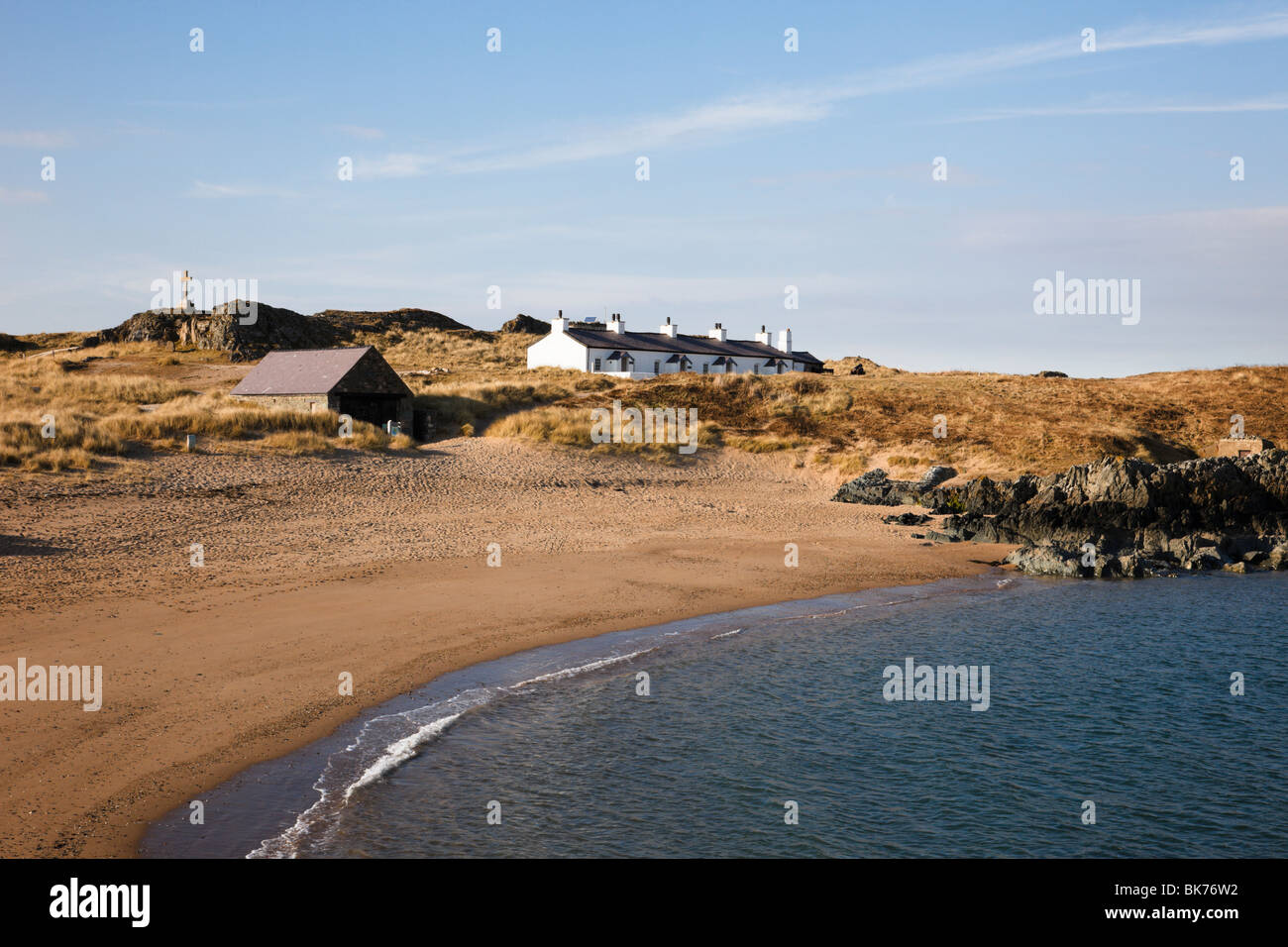 View across sandy beach to Pilot's cottages on Llanddwyn Island. Pilots Bay, Newborough, Isle of Anglesey, North Wales, UK, Britain. Stock Photo