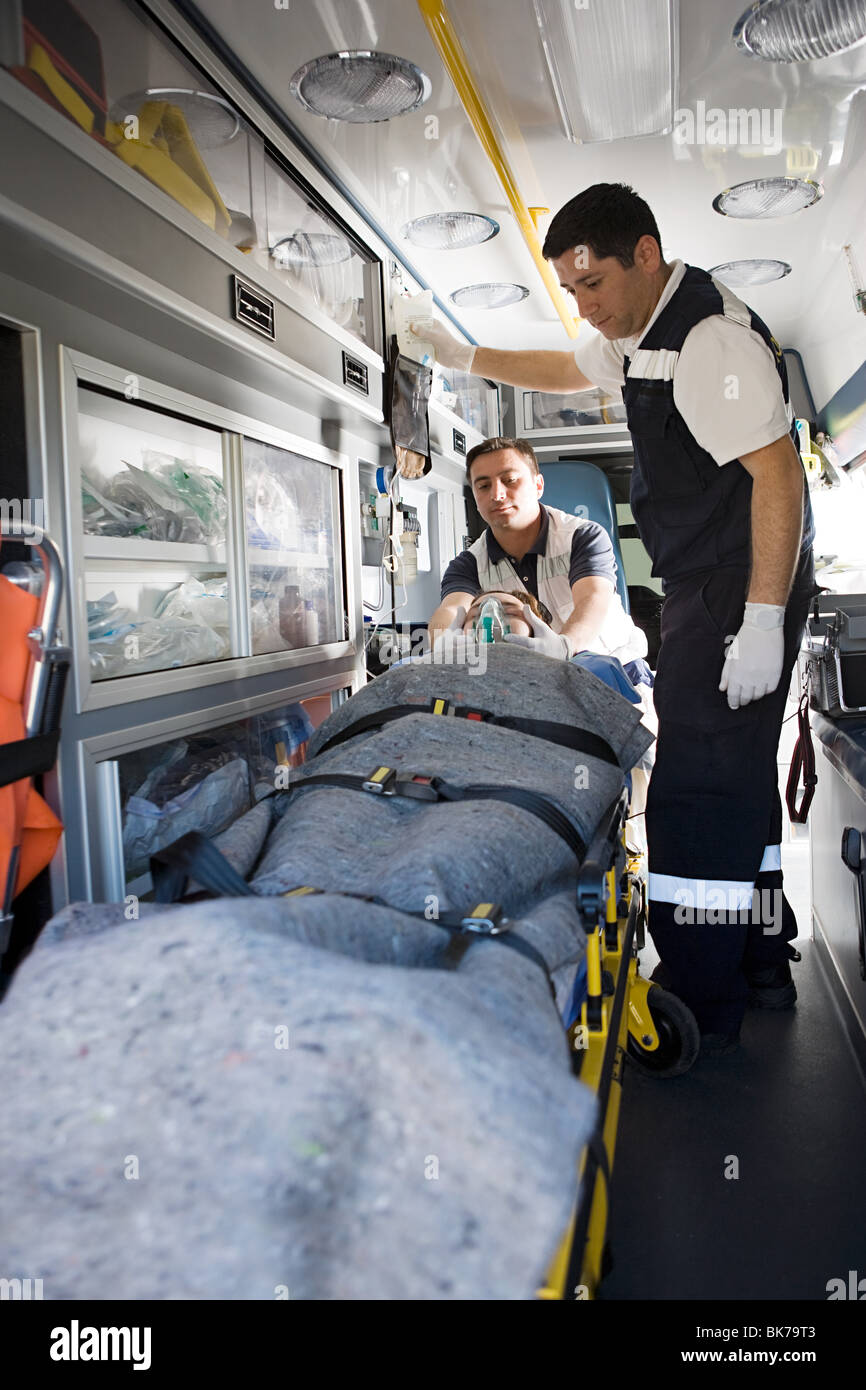Ambulance staff and patient on stretcher Stock Photo