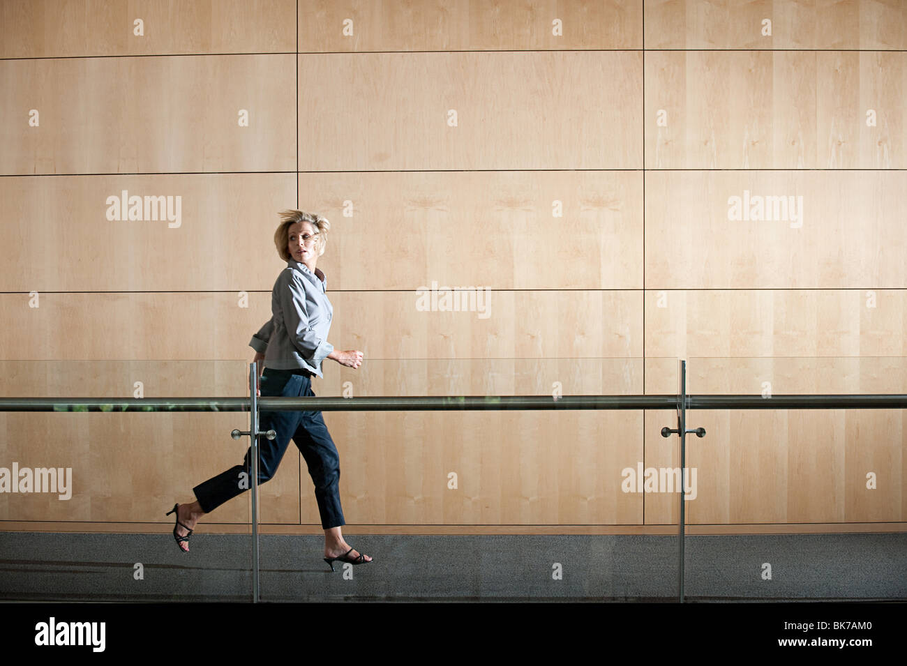 Businesswoman running through corridor Stock Photo