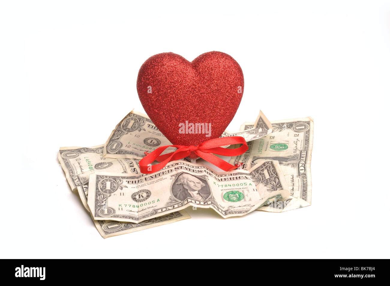 Heart and dollar notes photographed in studio against a white background Stock Photo