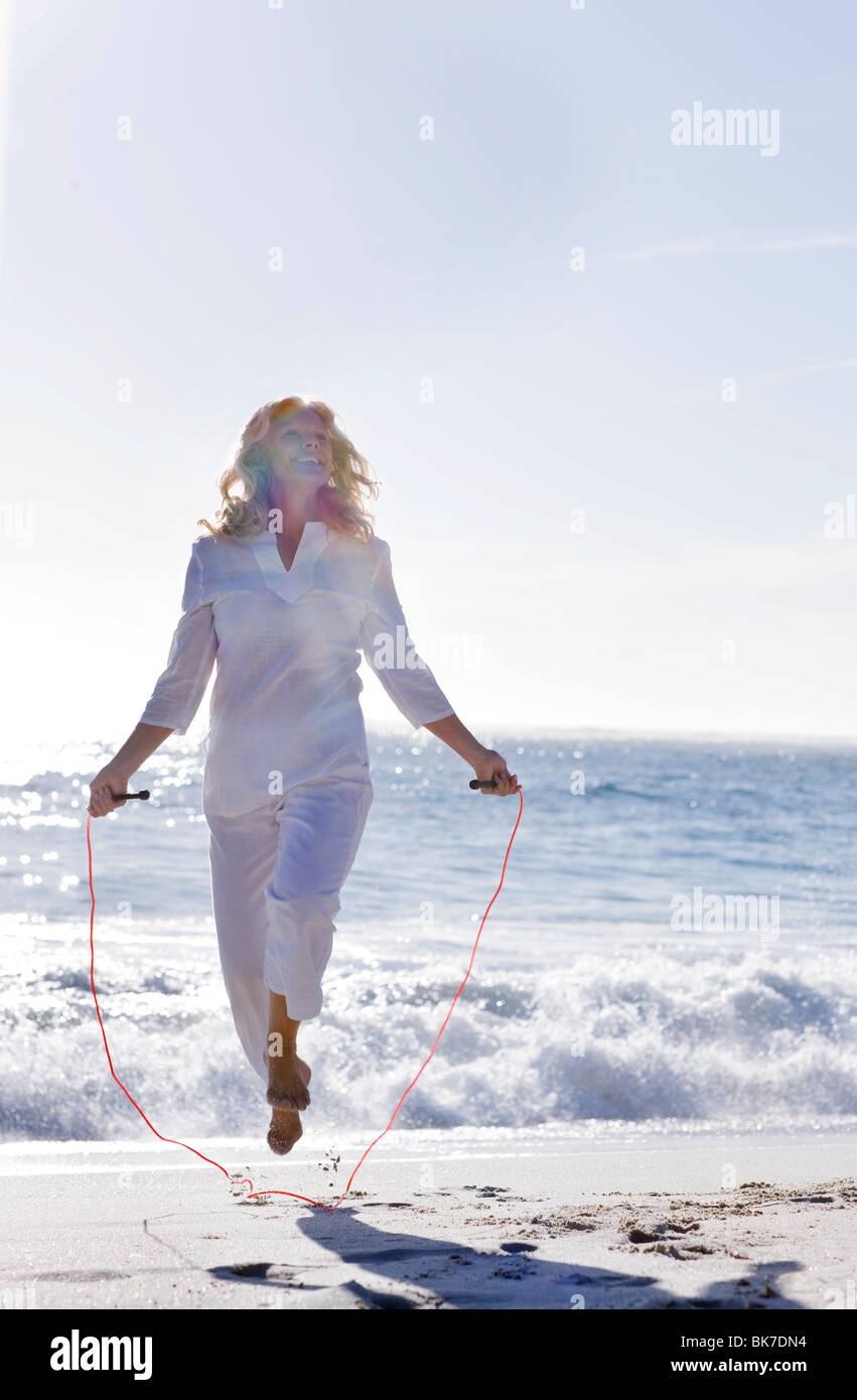 Senior woman skipping on a beach Stock Photo Alamy