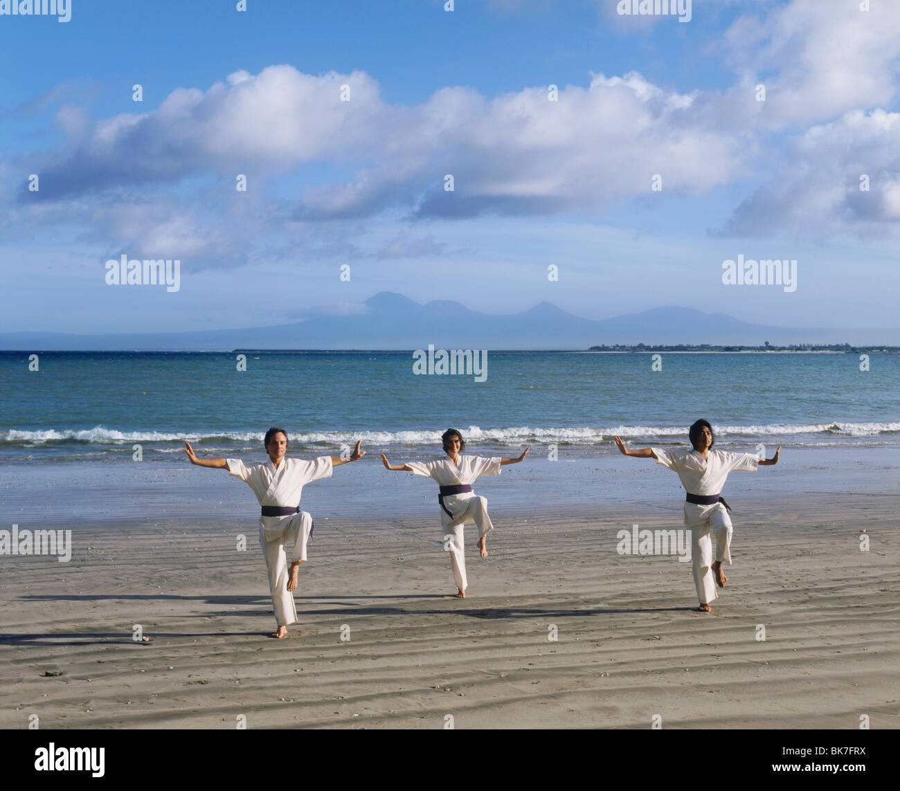 People performing White Crane Silat, an ancient martial art now used for exercise, on Jimbaran Beach, Bali, Indonesia Stock Photo