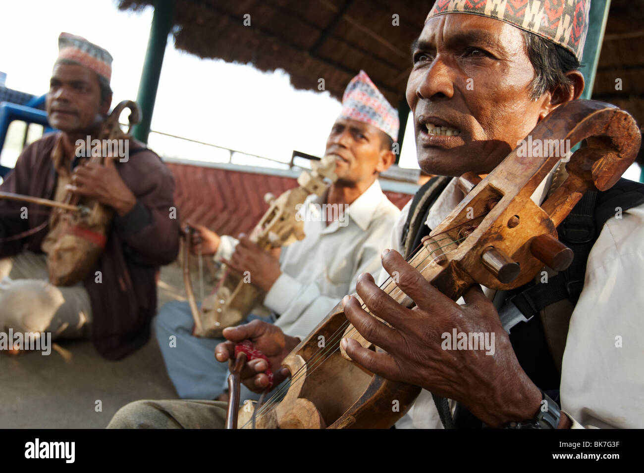 Musicians play a traditional string instrument at Begnas Lake near Pokhara, Nepal on Tuesday October 27, 2009. Stock Photo