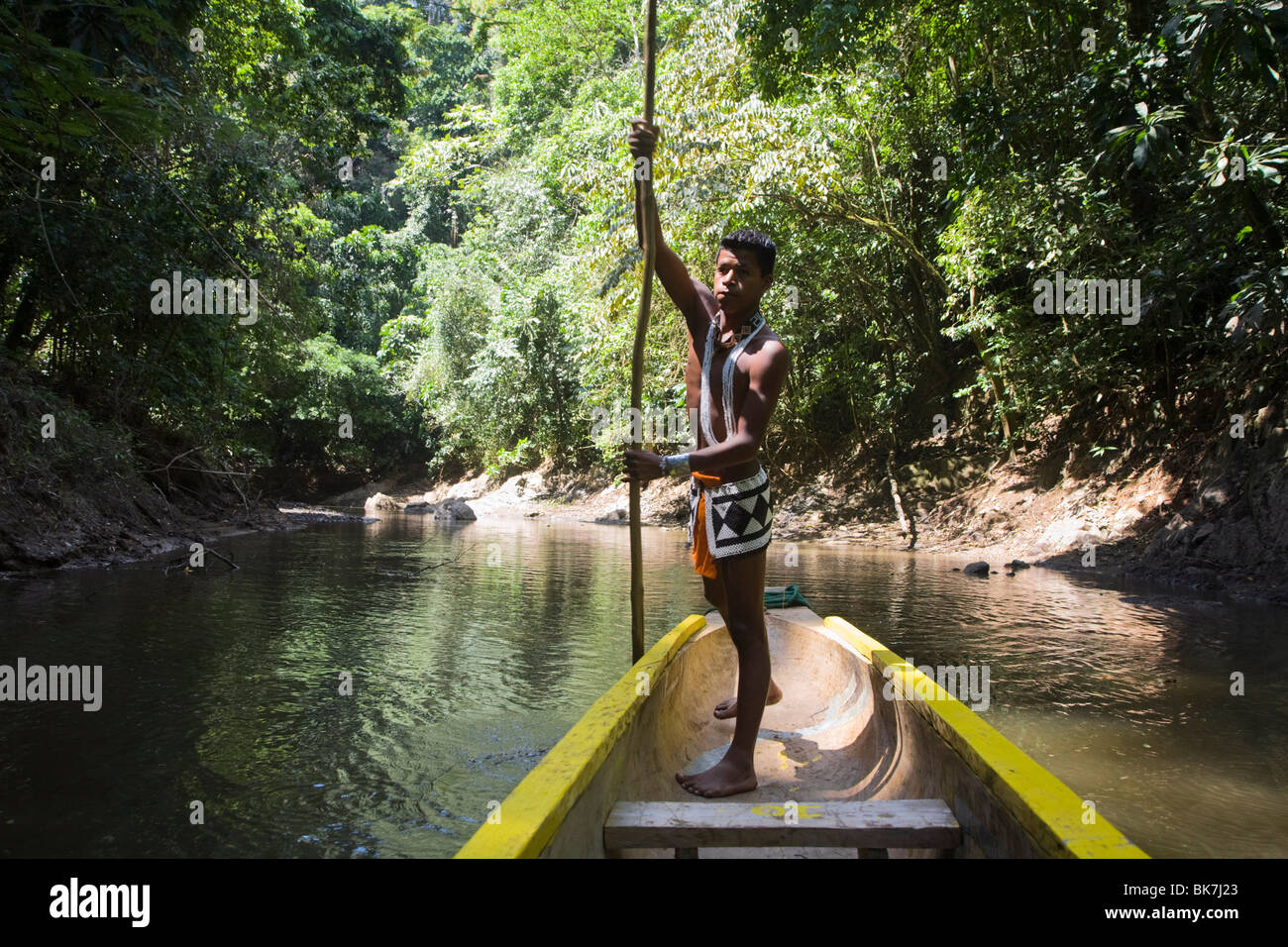 embera indian man in dugout canoe on chagres river, panama