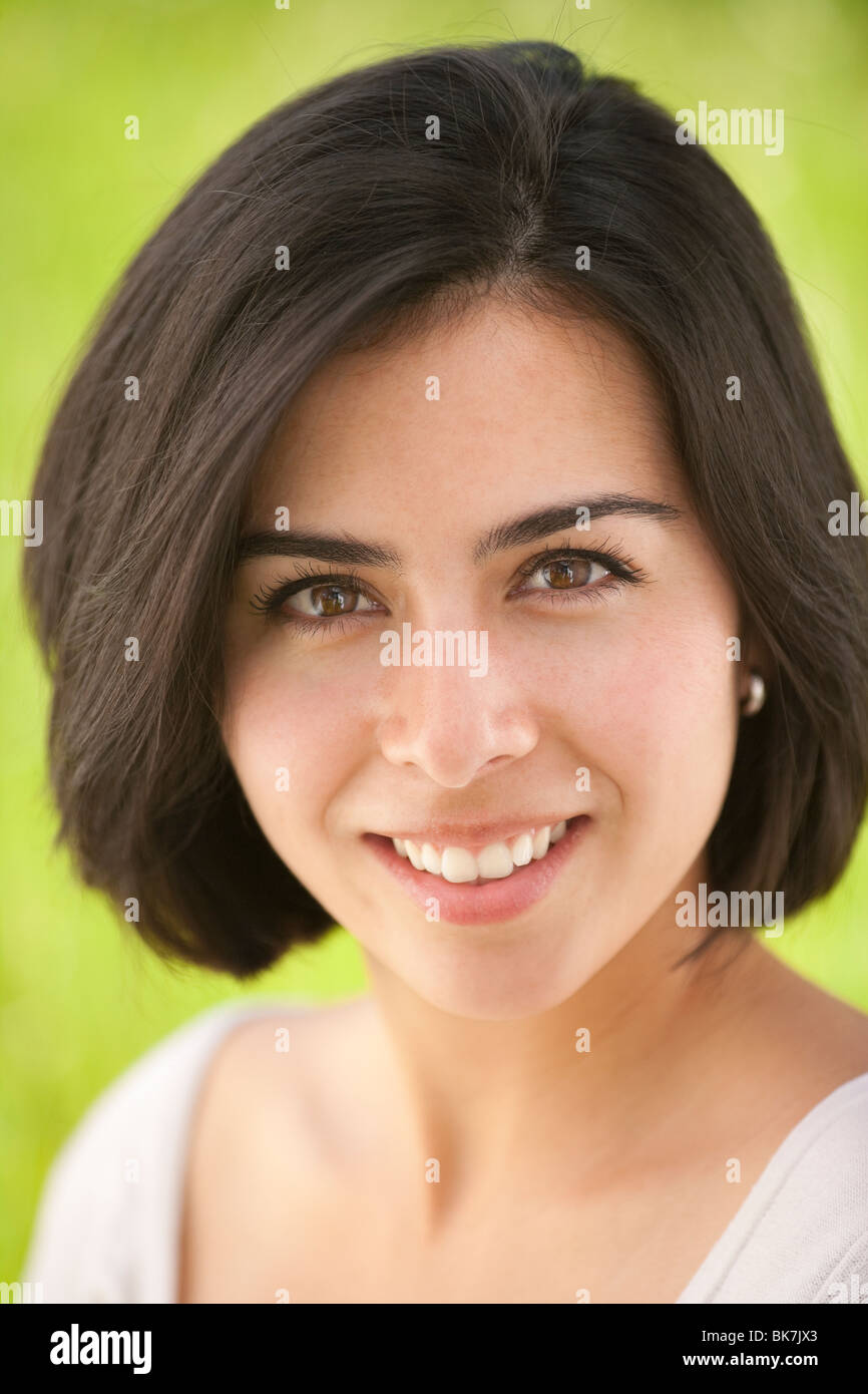 portrait of a beautiful, young Hispanic woman in a grassy meadow Stock Photo