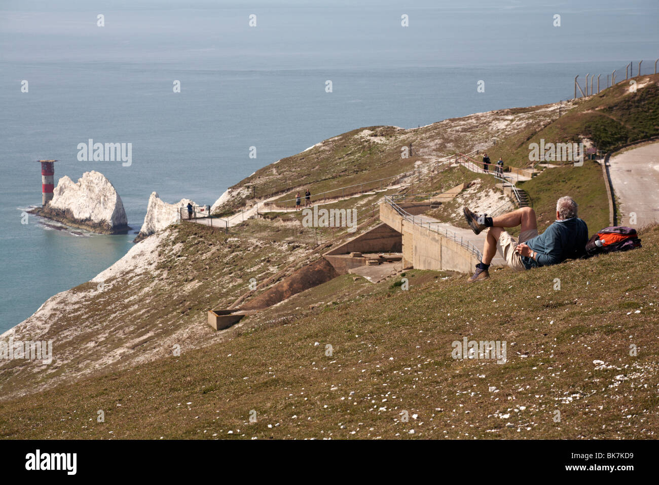 walker relaxing overlooking the rocks of the Needles, Isle of Wight, Hampshire, England UK  in April - Needles lighthouse and rock chalk stacks Stock Photo