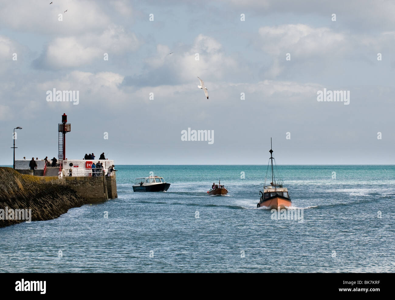Three boats sailing past the Banjo Pier as they enter the River Looe. Stock Photo