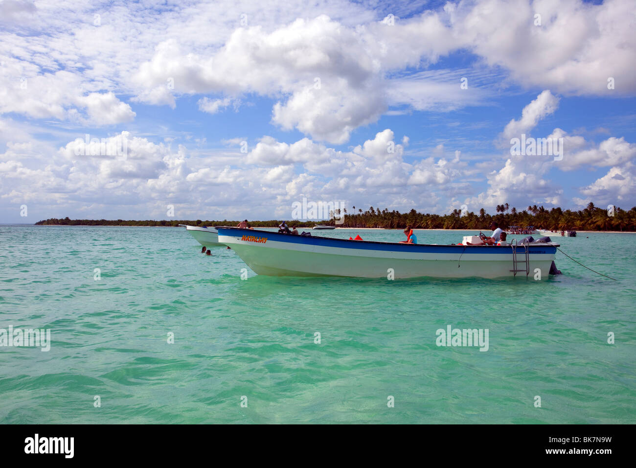 a small tourist boat moored up in shallow water near the coast in the Caribbean sea Stock Photo