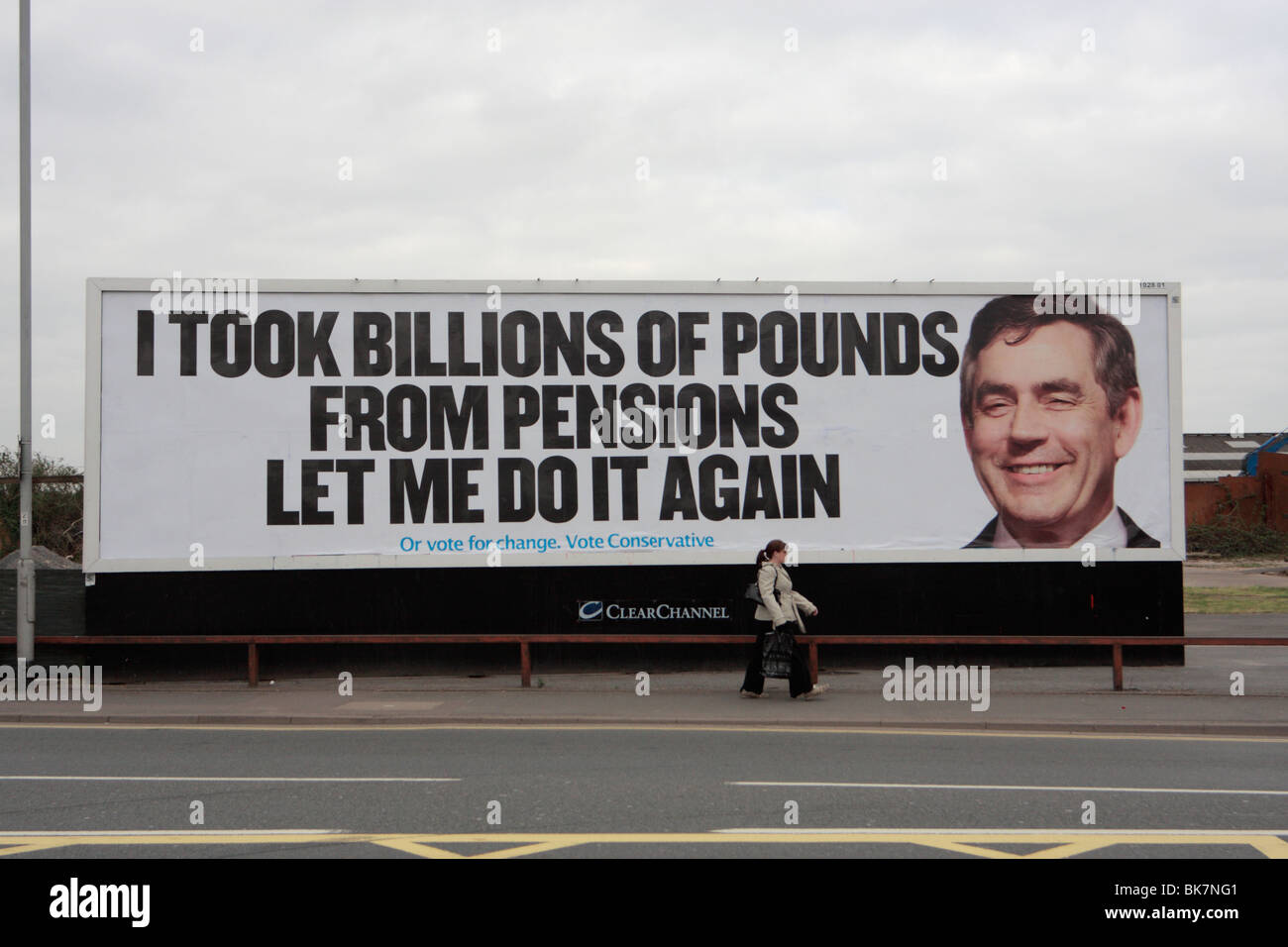 Young woman walking past Tory poster featuring Gordon Brown 2010 Uk general election Stock Photo