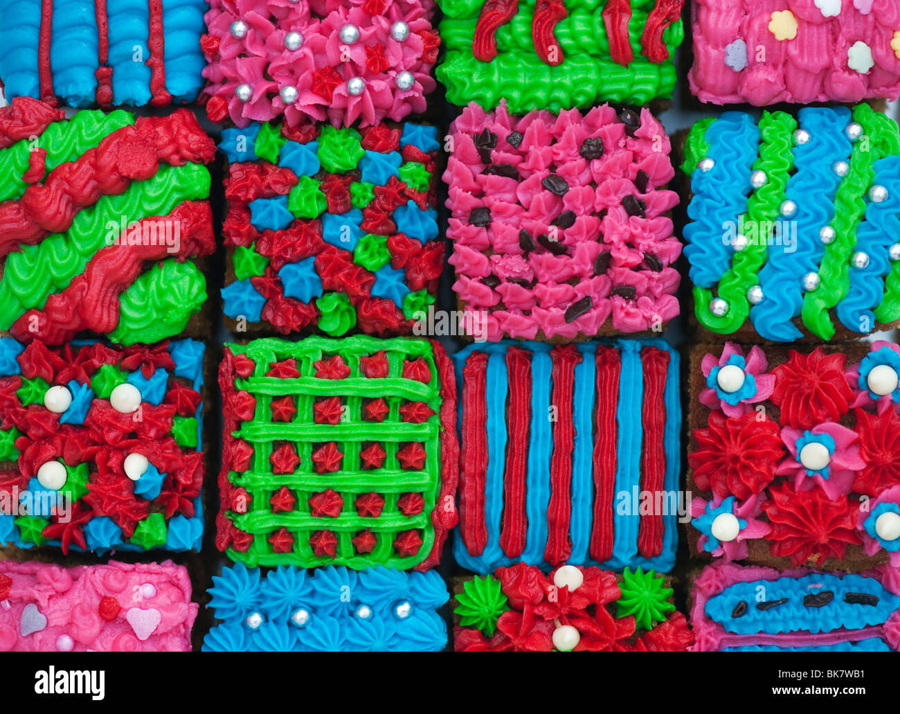 Homemade square individual iced cakes in a grid pattern. Flat lay