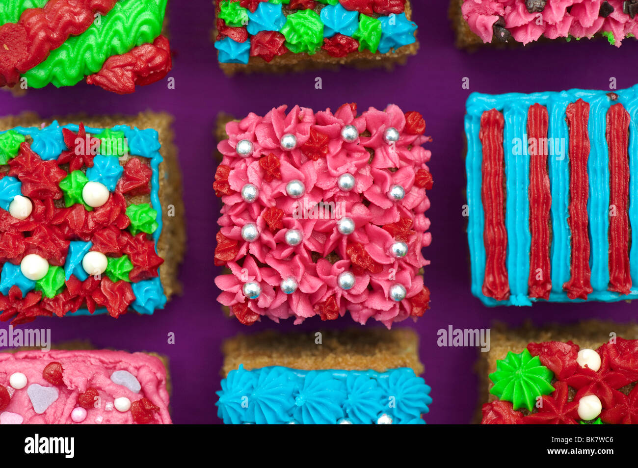 Homemade square individual iced cakes in a grid pattern. Flat lay