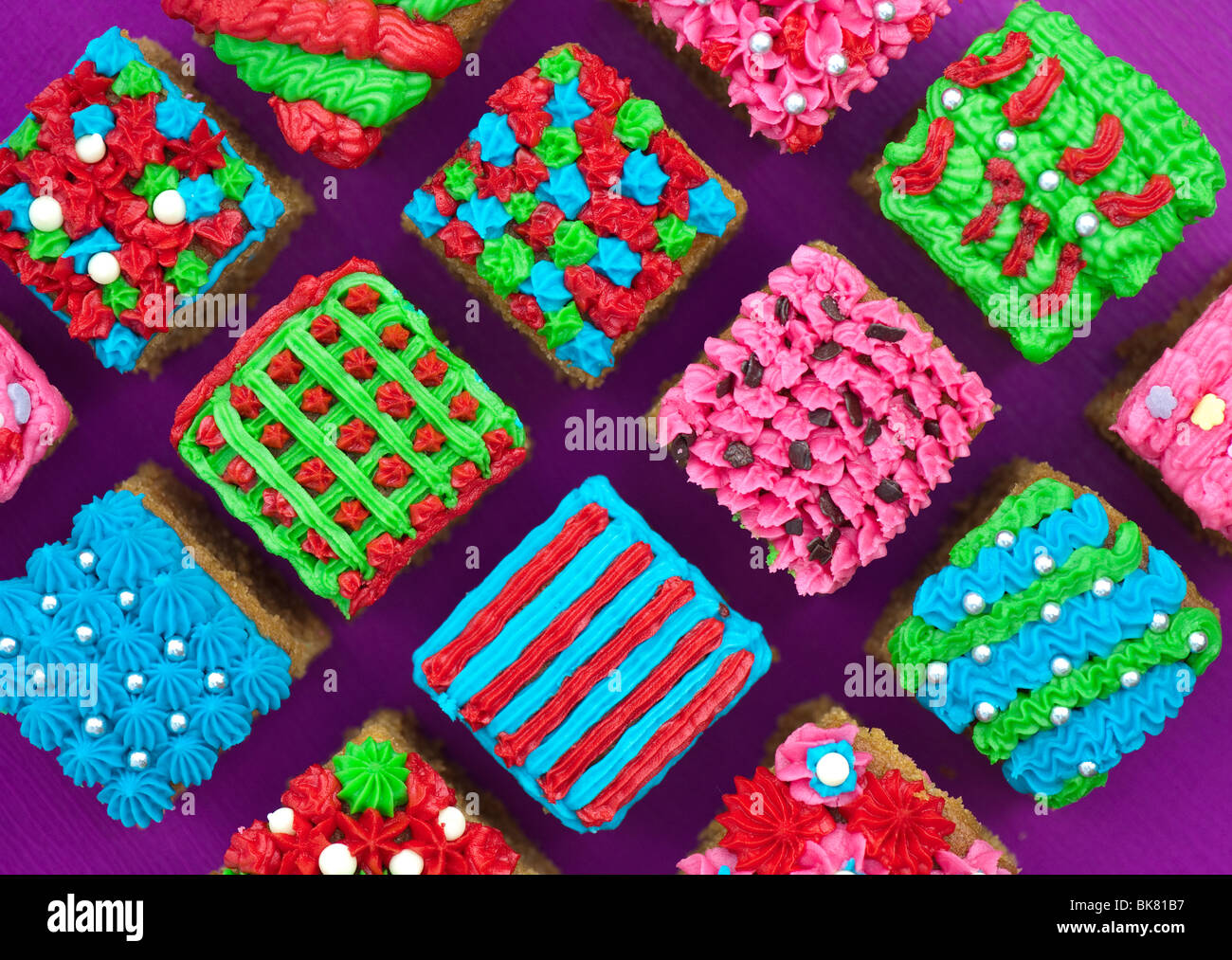 Homemade square individual iced cakes in a grid pattern. Flat lay photography from above Stock Photo