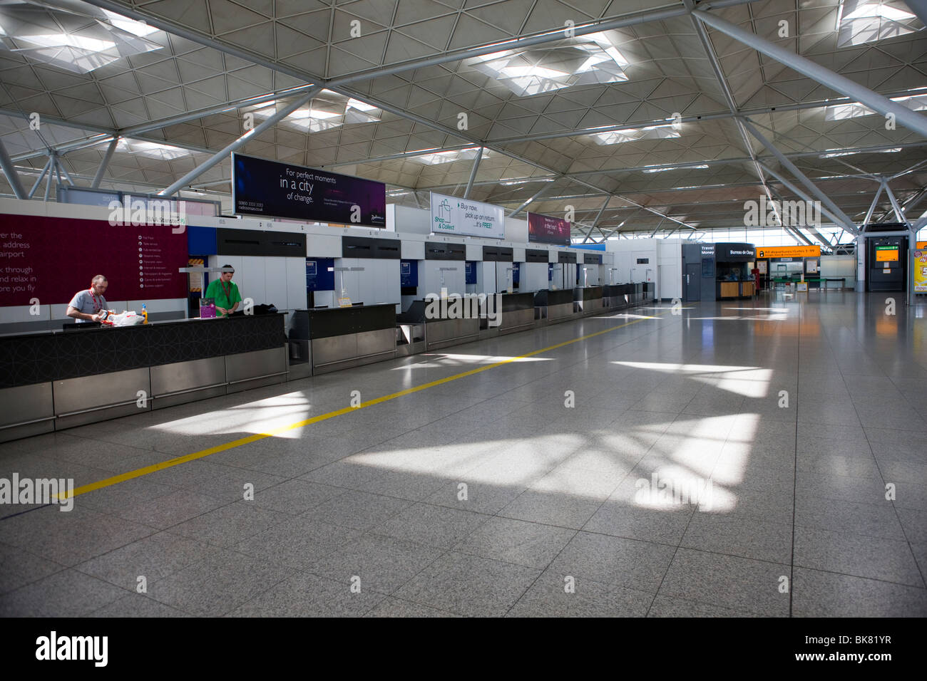 Empty check in desks due to canceled flights inside the terminal of London Stansted airport in Essex Stock Photo