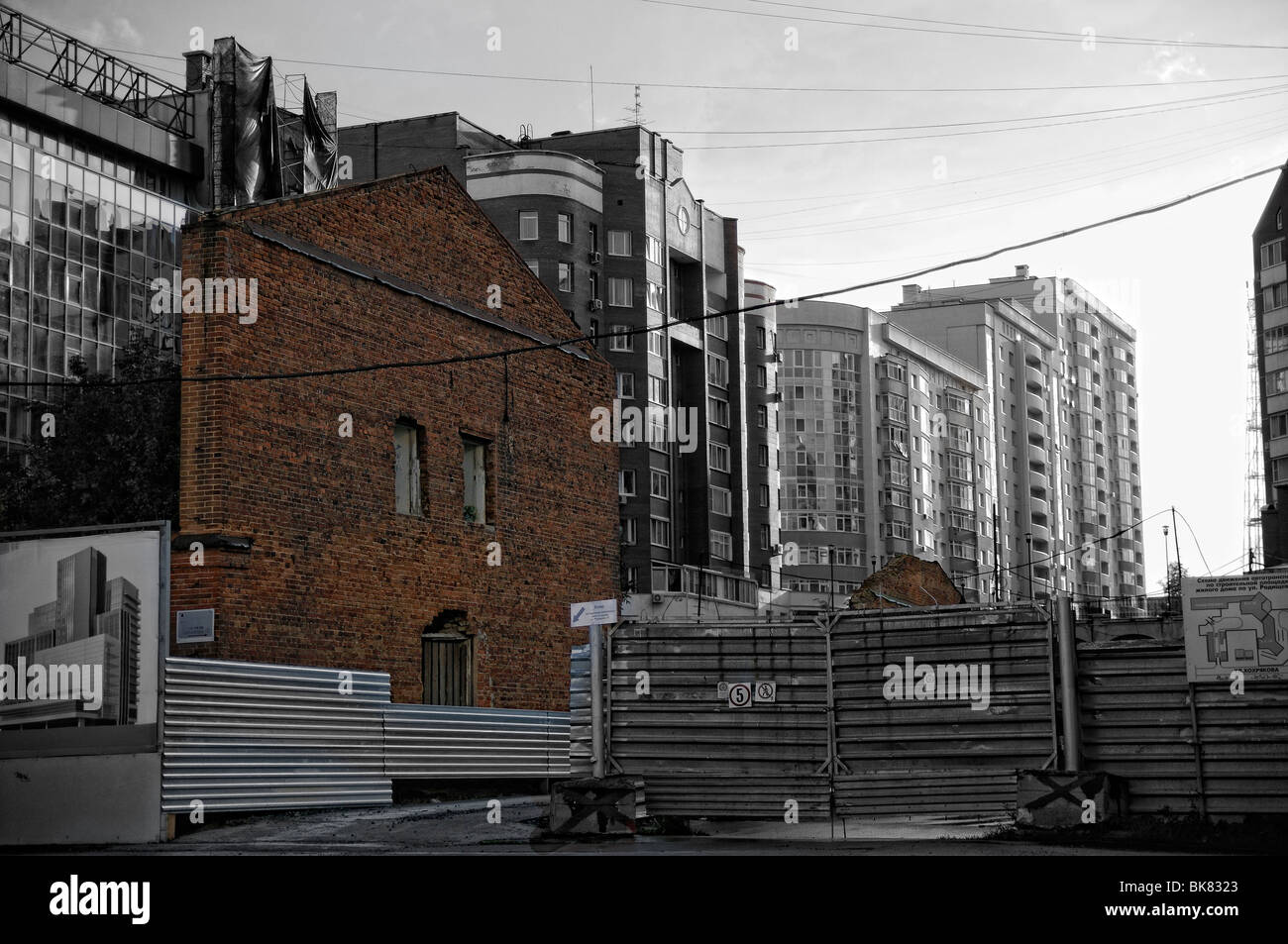 A wall of destroyed old building among modern houses.Ekaterinburg city series. Stock Photo