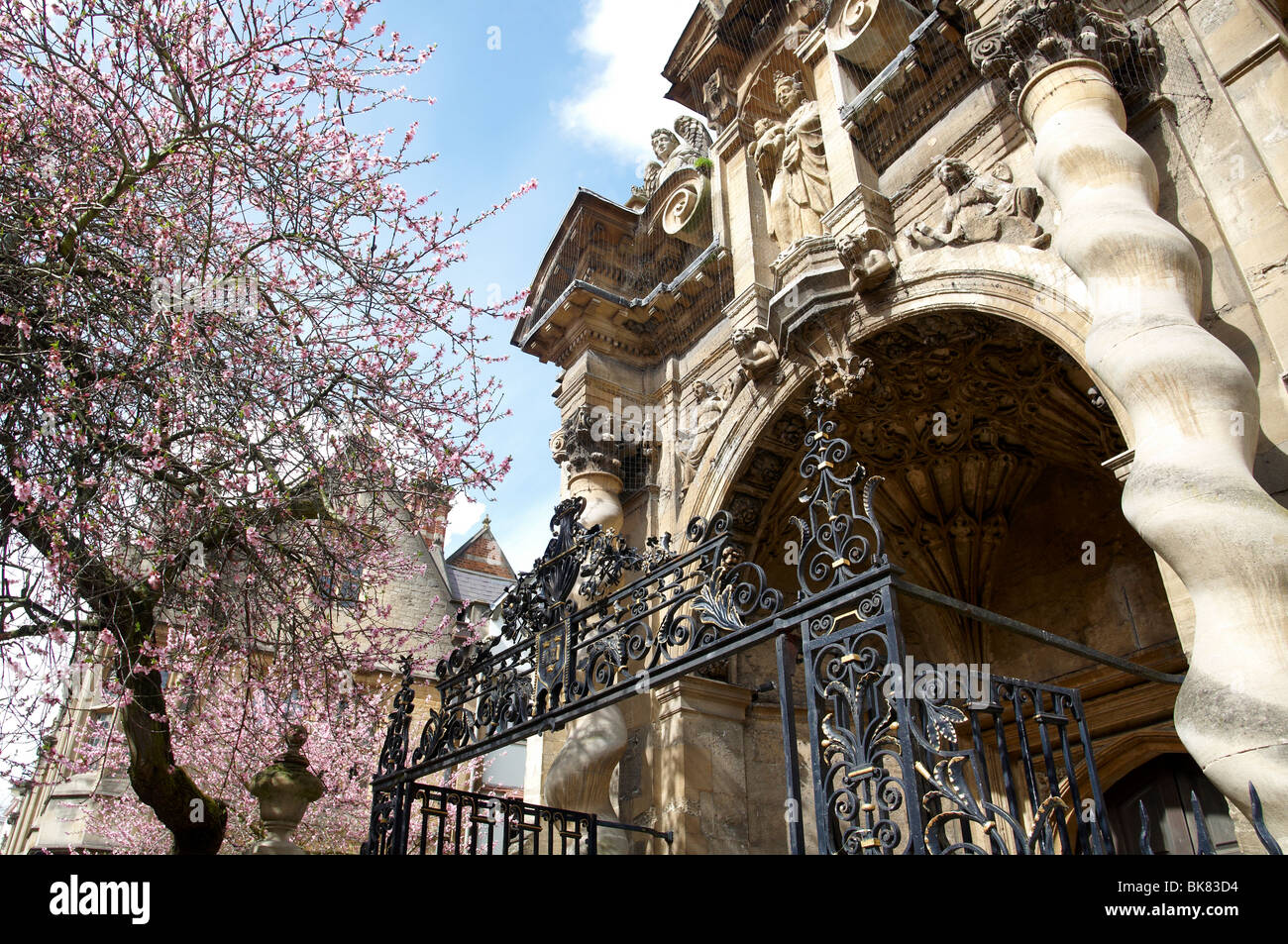 Entrance porch and gate to the University Church of St Mary the Virgin in Oxford, England with flowering cherry tree outside. Stock Photo