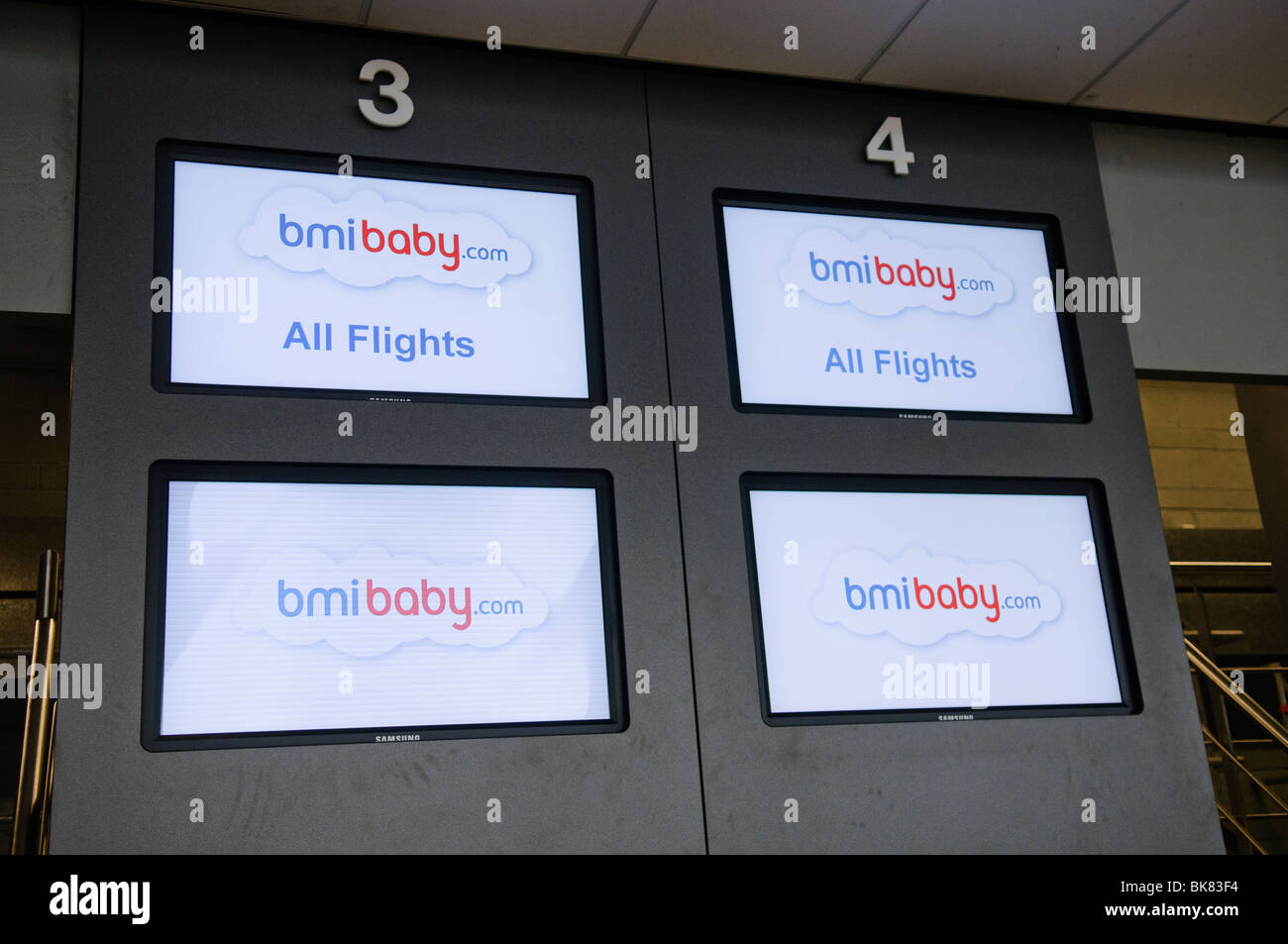 Screens at the check-in desk for BMI Baby Stock Photo