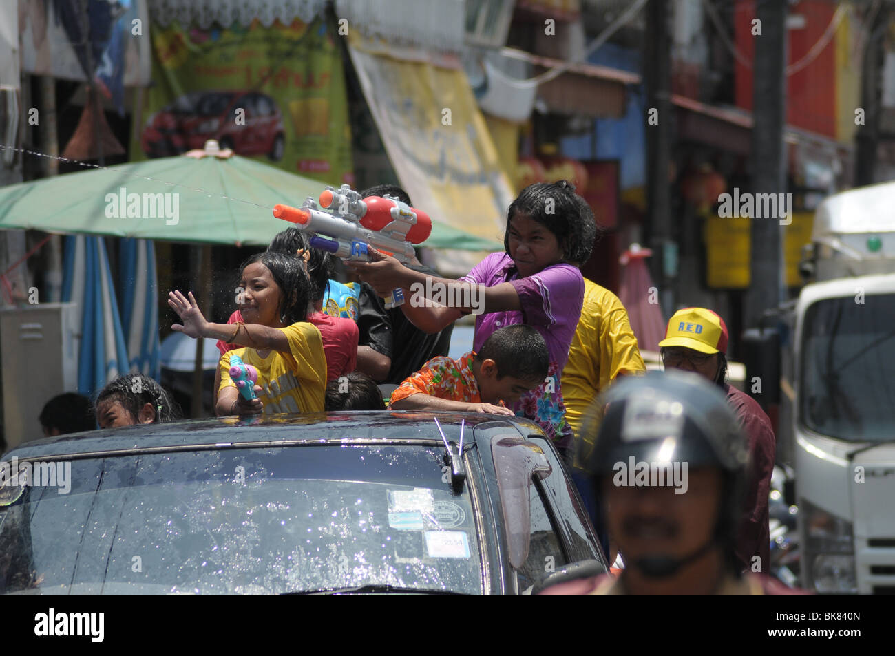 Girl firing water pistol in back of truck during the Thai Songkran Festival Stock Photo