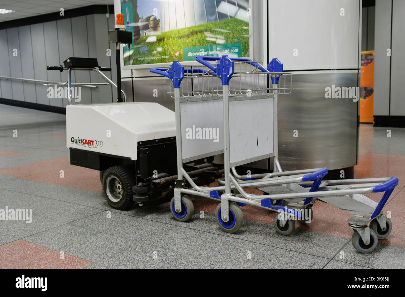 Small electric tractor unit for collecting and moving trolleys at an airport Stock Photo