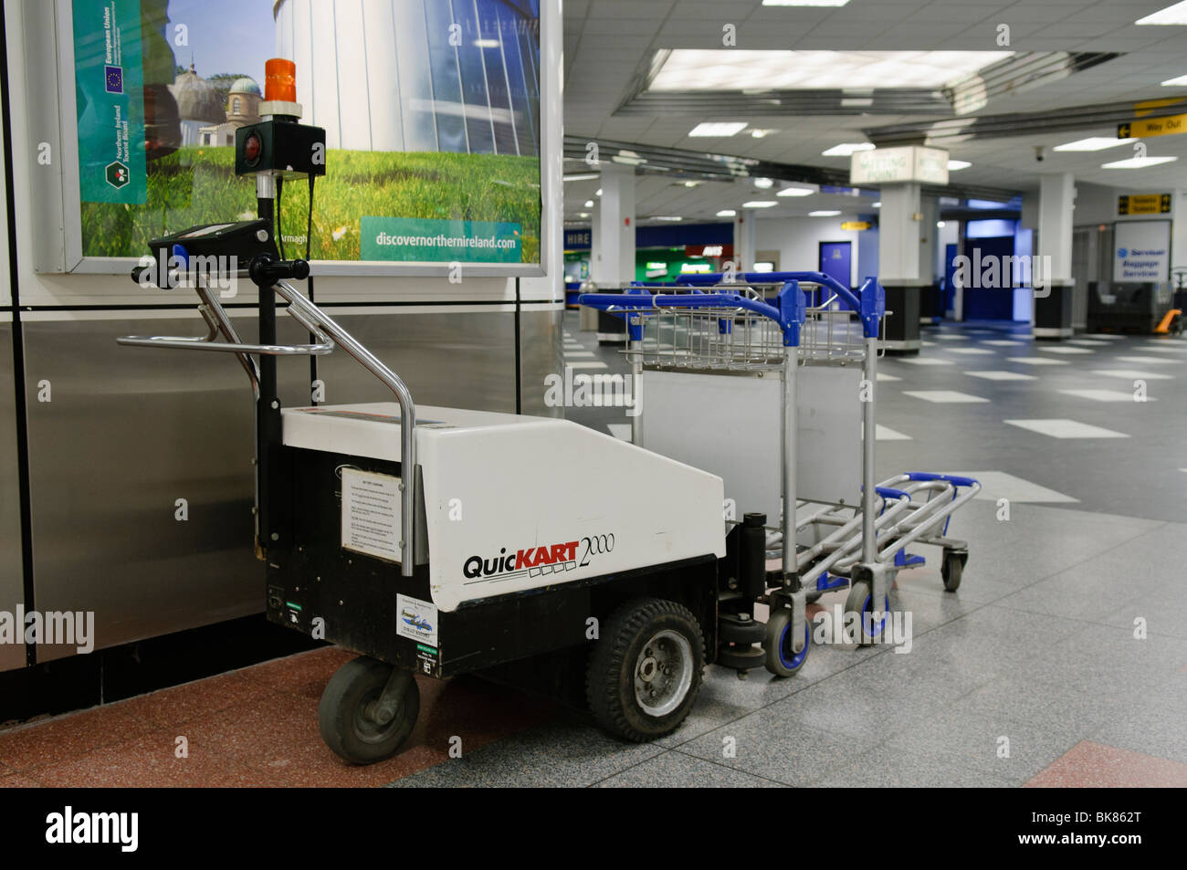 Small electric tractor unit for collecting and moving trolleys at an airport Stock Photo