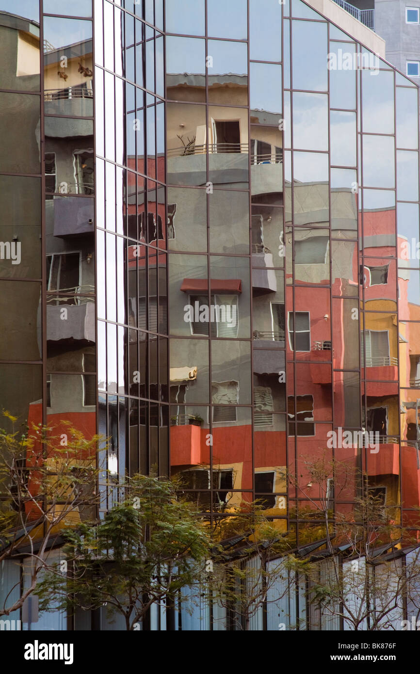 Mirror windows reflecting a colorful modern residential building in
