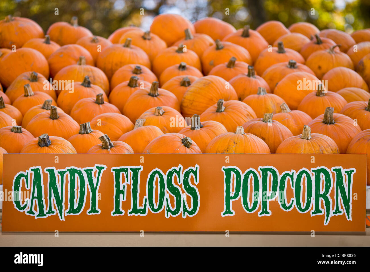 Candy floss and popcorn sign in front of a pile of pumpkins Stock Photo