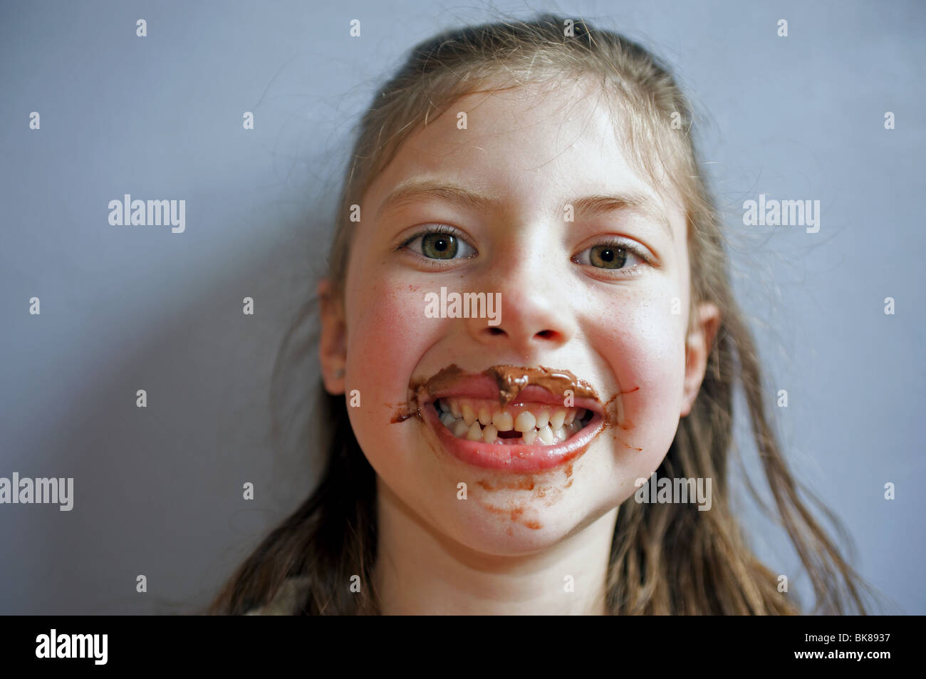 Young girl with face and mouth covered in chocolate Stock Photo