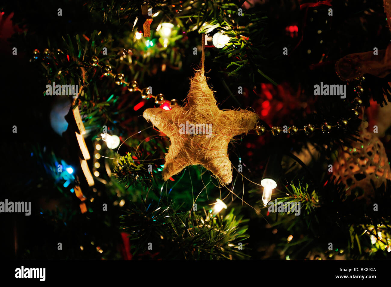 A Straw Star Used As A Decoration On A Christmas Tree Surrounded