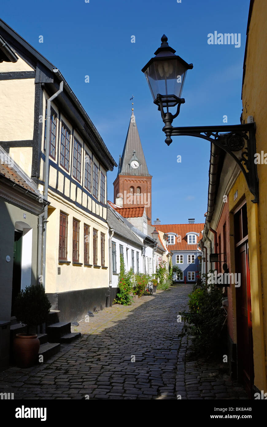 Cobblestone street in the historic town of Aalborg, Ålborg, in the back the Frue Kirke church, Nordjylland region, Denmark, Sca Stock Photo