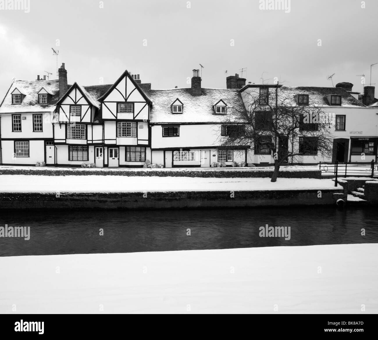 Black & white image of listed houses along the river Stour covered in snow in Canterbury, Kent, UK. Stock Photo