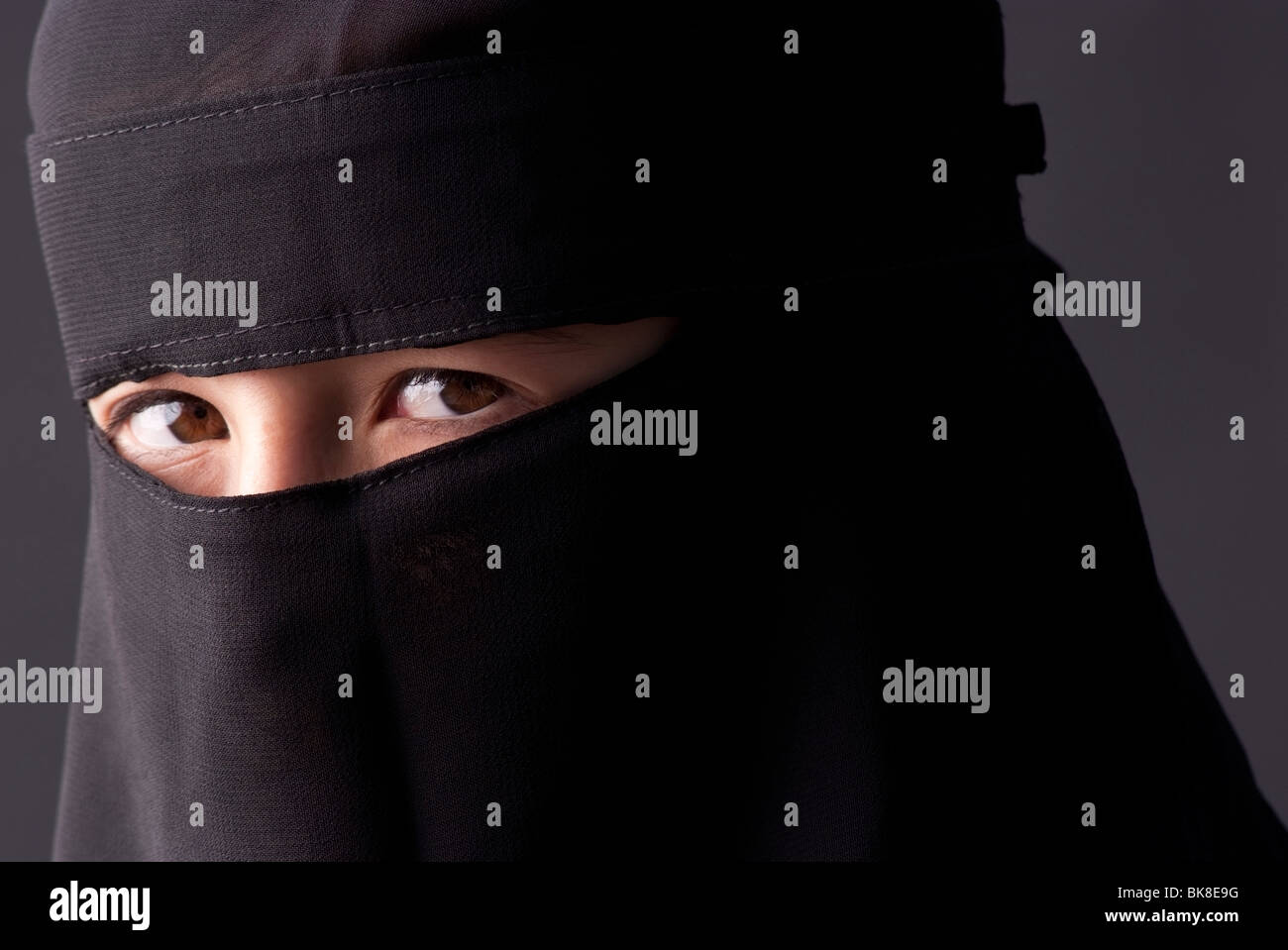 Teenage girl wearing a traditional Muslim niqab, a head covering with a veil that covers the face. Stock Photo