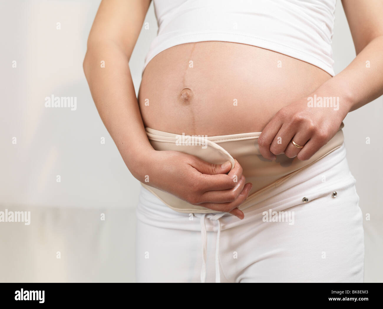 Close up of a pregnant woman wearing a pregnancy belt Stock Photo