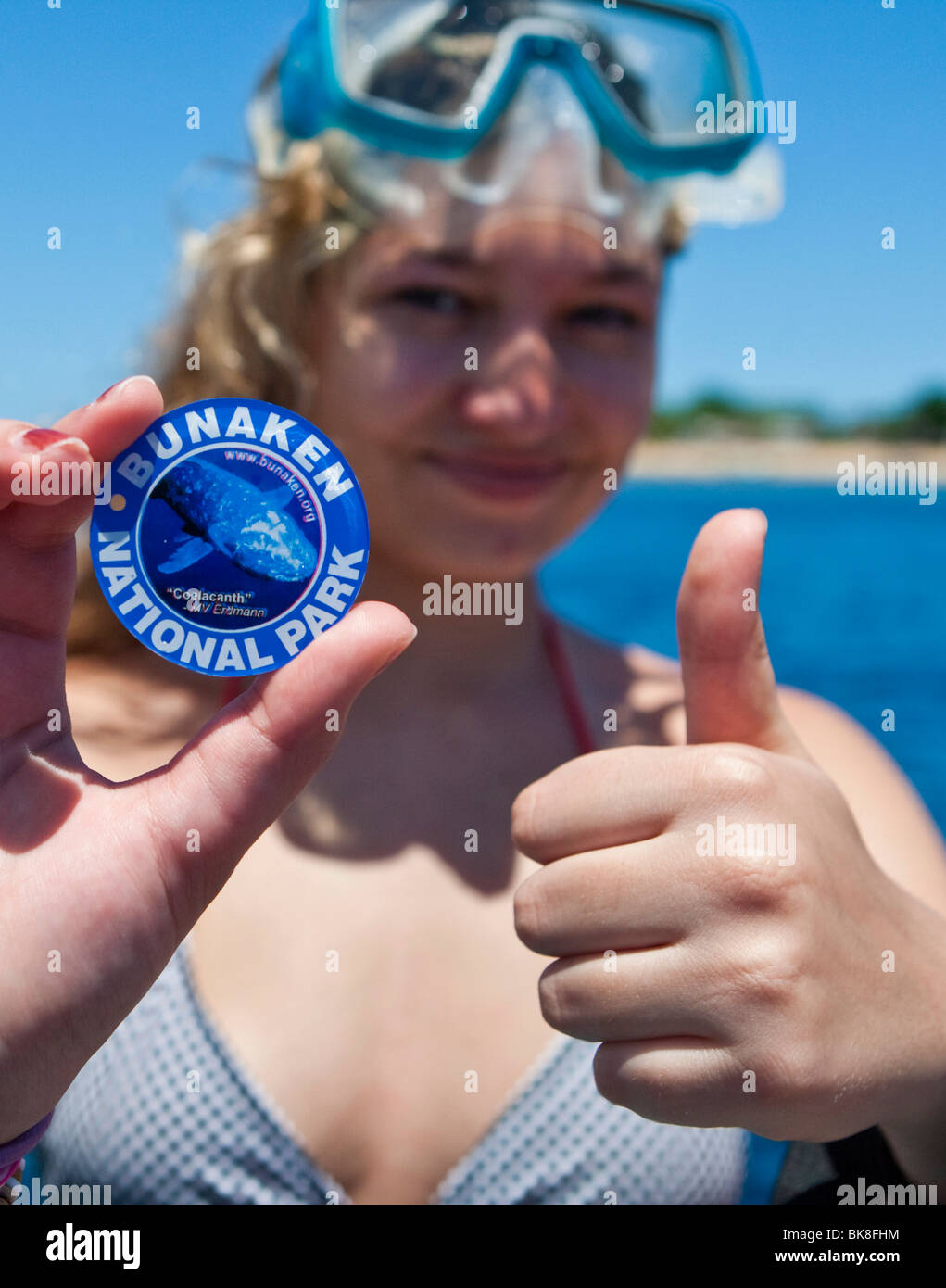 Scuba diver holding a badge from the Bunaken under water national park, the fee is used to preserve the National Park, Bunaken, Stock Photo