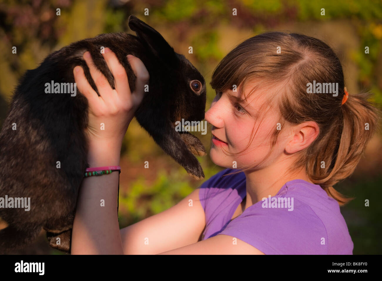 Young girl playing with a rabbit Stock Photo