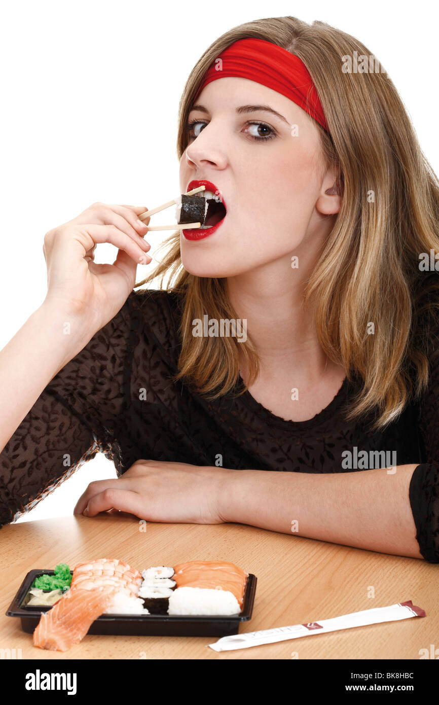 Young woman eating sushi with chopsticks Stock Photo